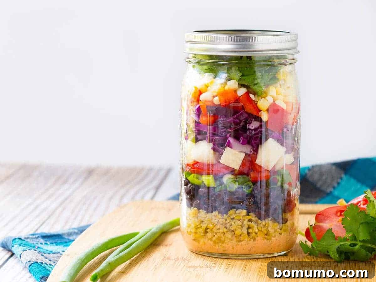 Close-up of a colorful and fresh Southwestern Chopped Salad layered in a mason jar, highlighting its vibrant ingredients.