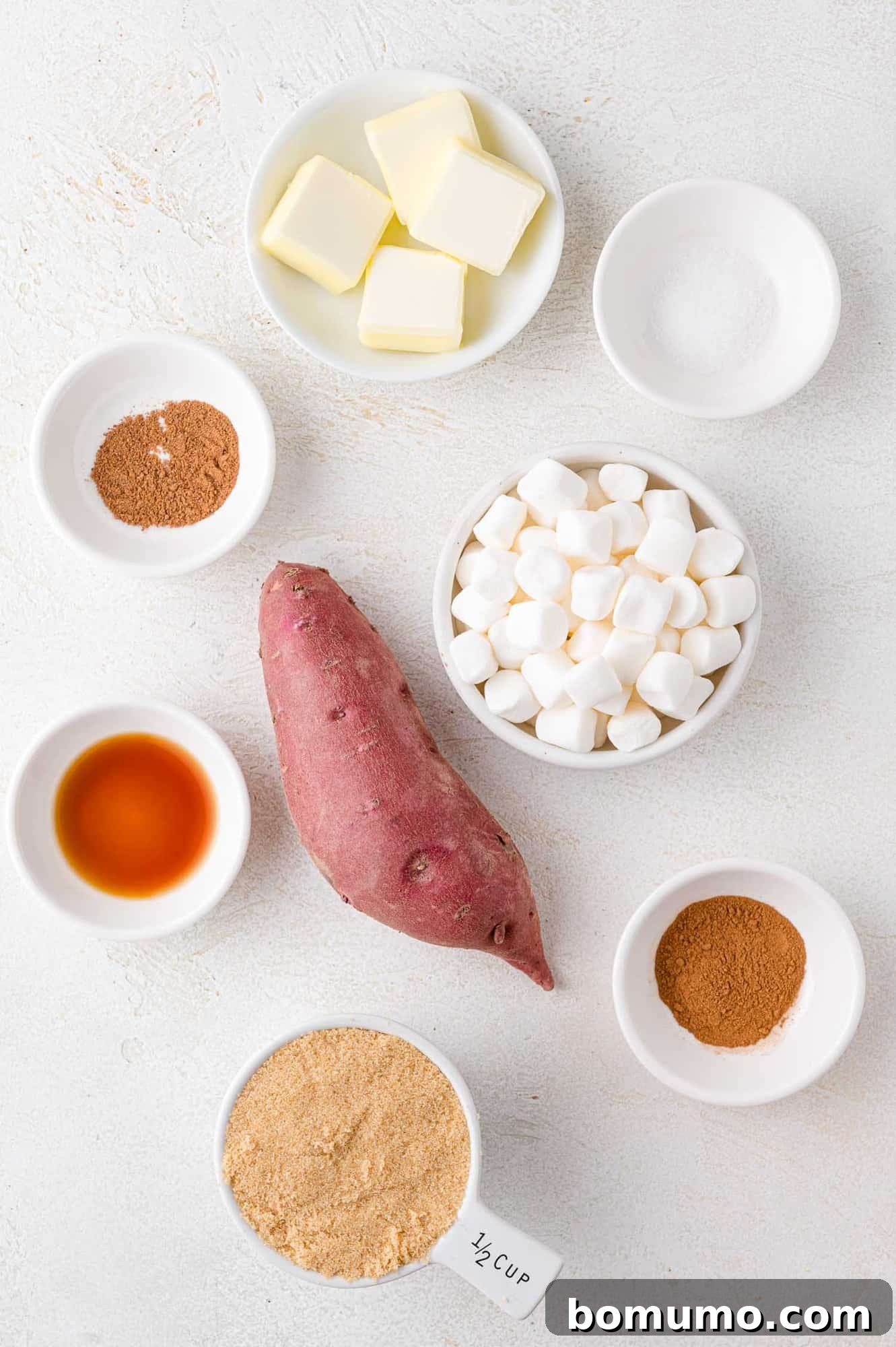 An overhead shot showcasing a selection of fresh ingredients, including a vibrant sweet potato, waiting to be transformed into a delicious casserole, highlighting the simplicity and quality of components.