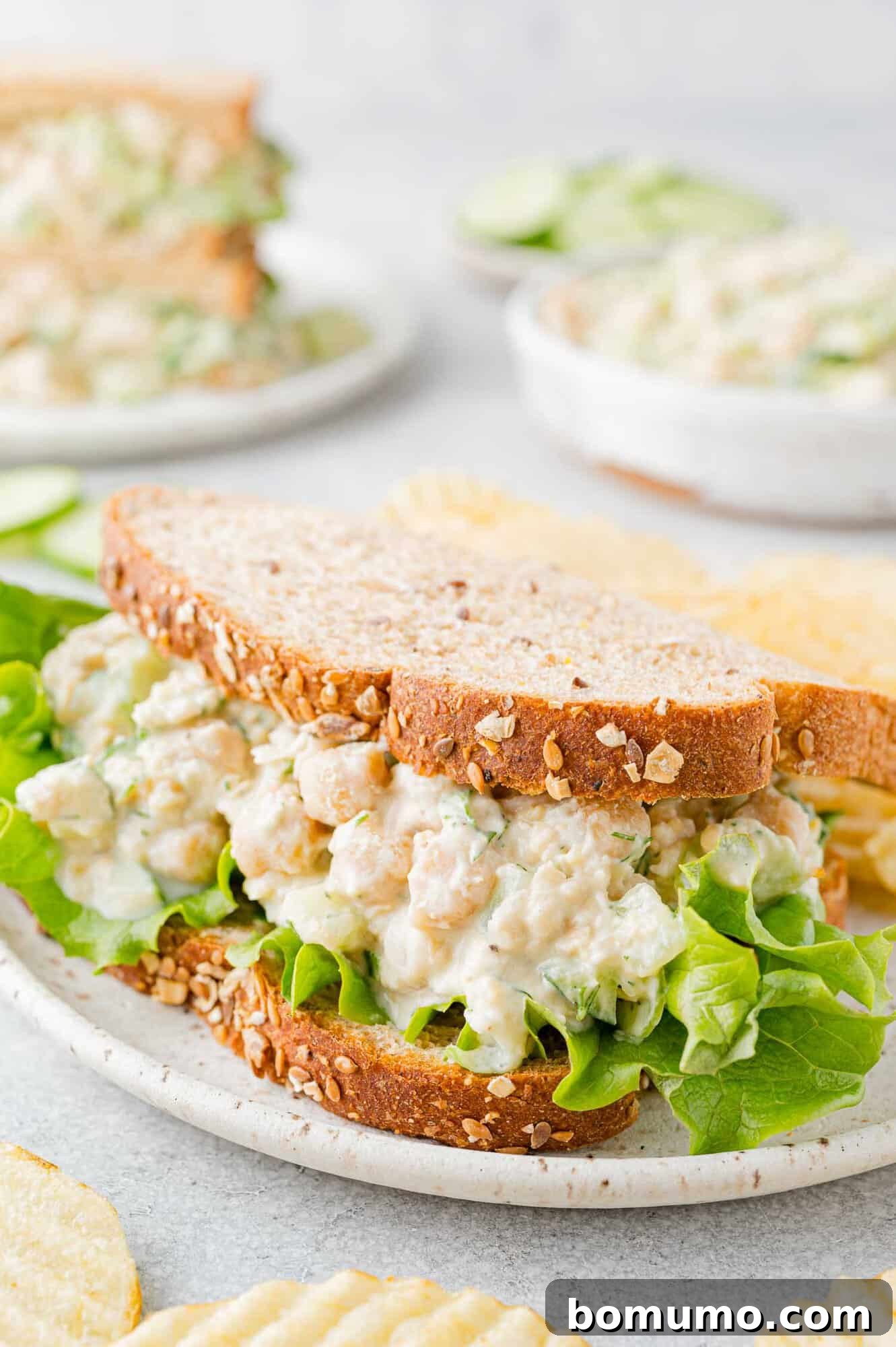 Delicious chickpea salad sandwich on wholesome wheat bread, garnished with crisp leaf lettuce.