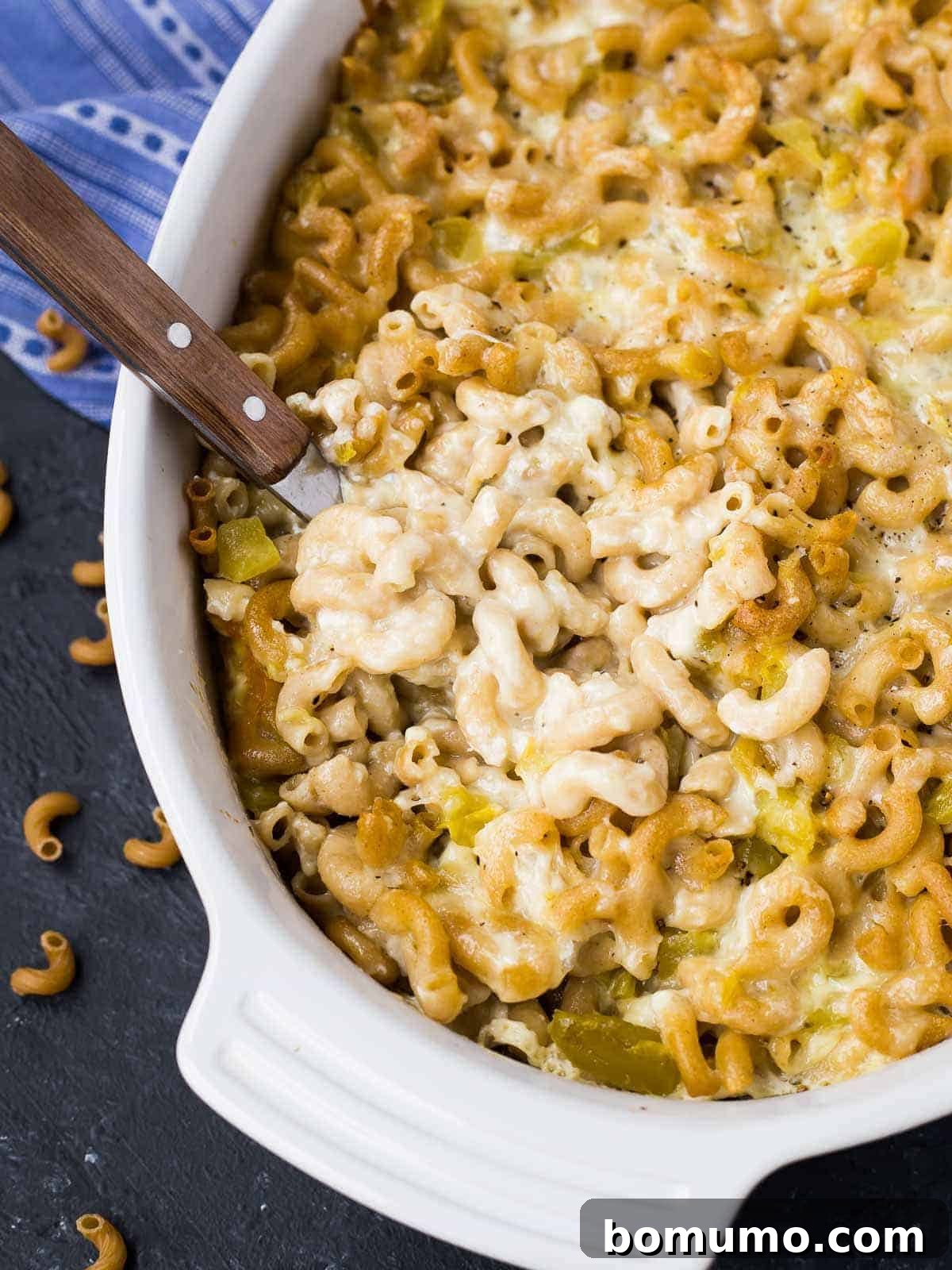 Southwest Mac Delight 6 Close-up of green chile mac and cheese, partially scooped to show its creamy, cheesy texture with visible green chiles.