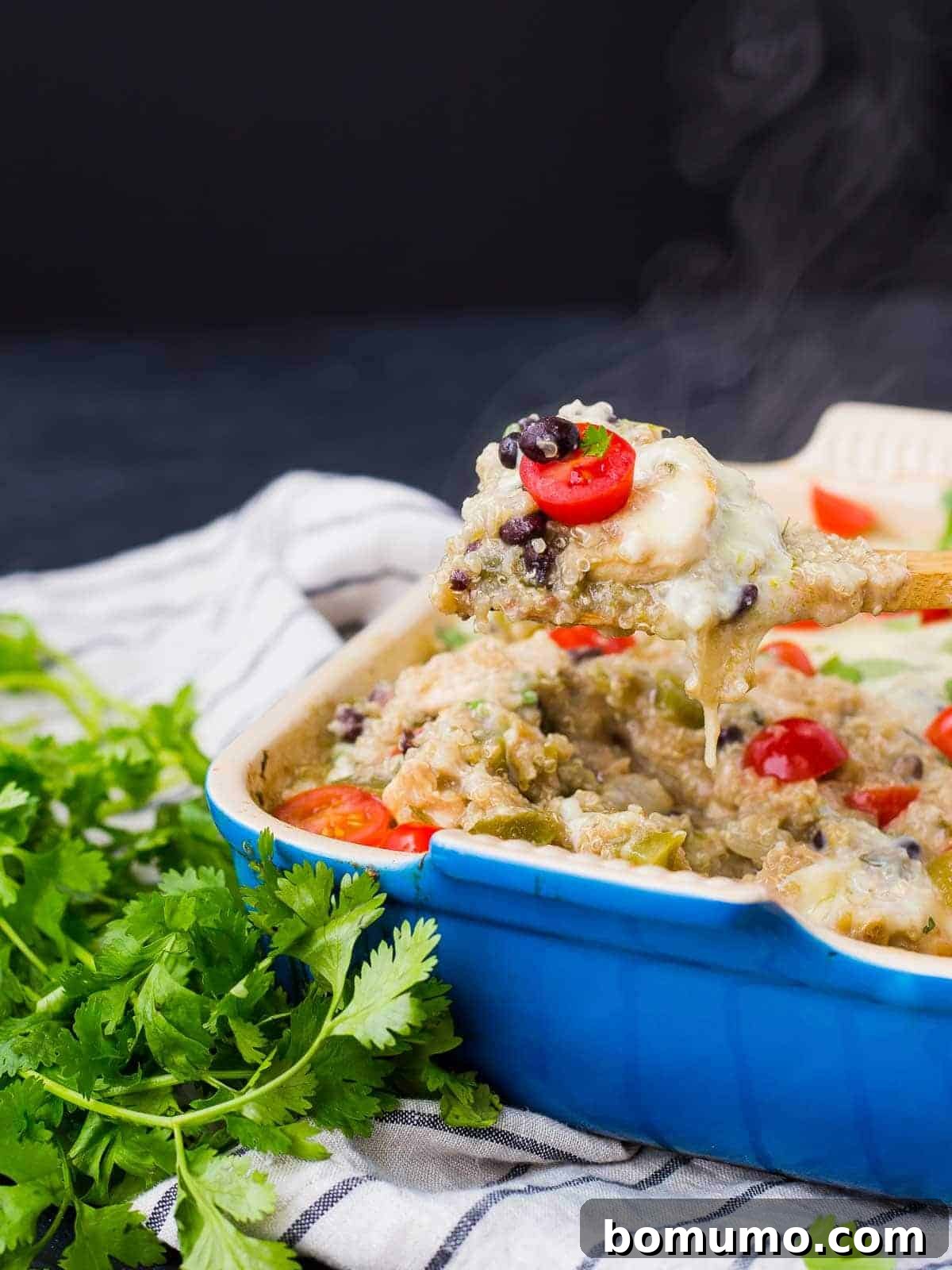 A partial image showing the baked casserole, with a spoon lifting a portion out of the dish.