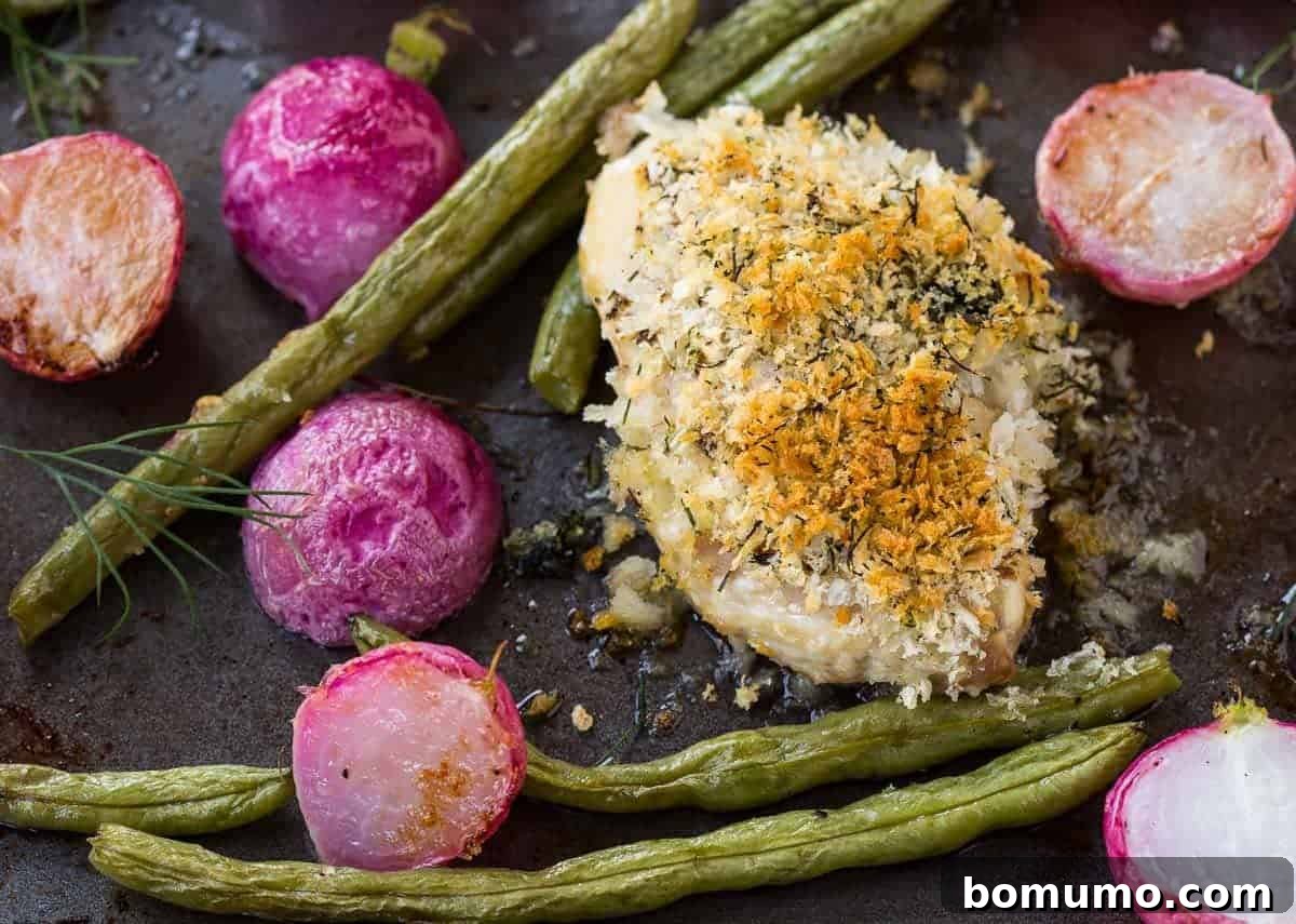 A serving of crispy Dijon dill chicken thigh with vibrant green beans and roasted radishes on a plate, highlighting the golden crust of the chicken.