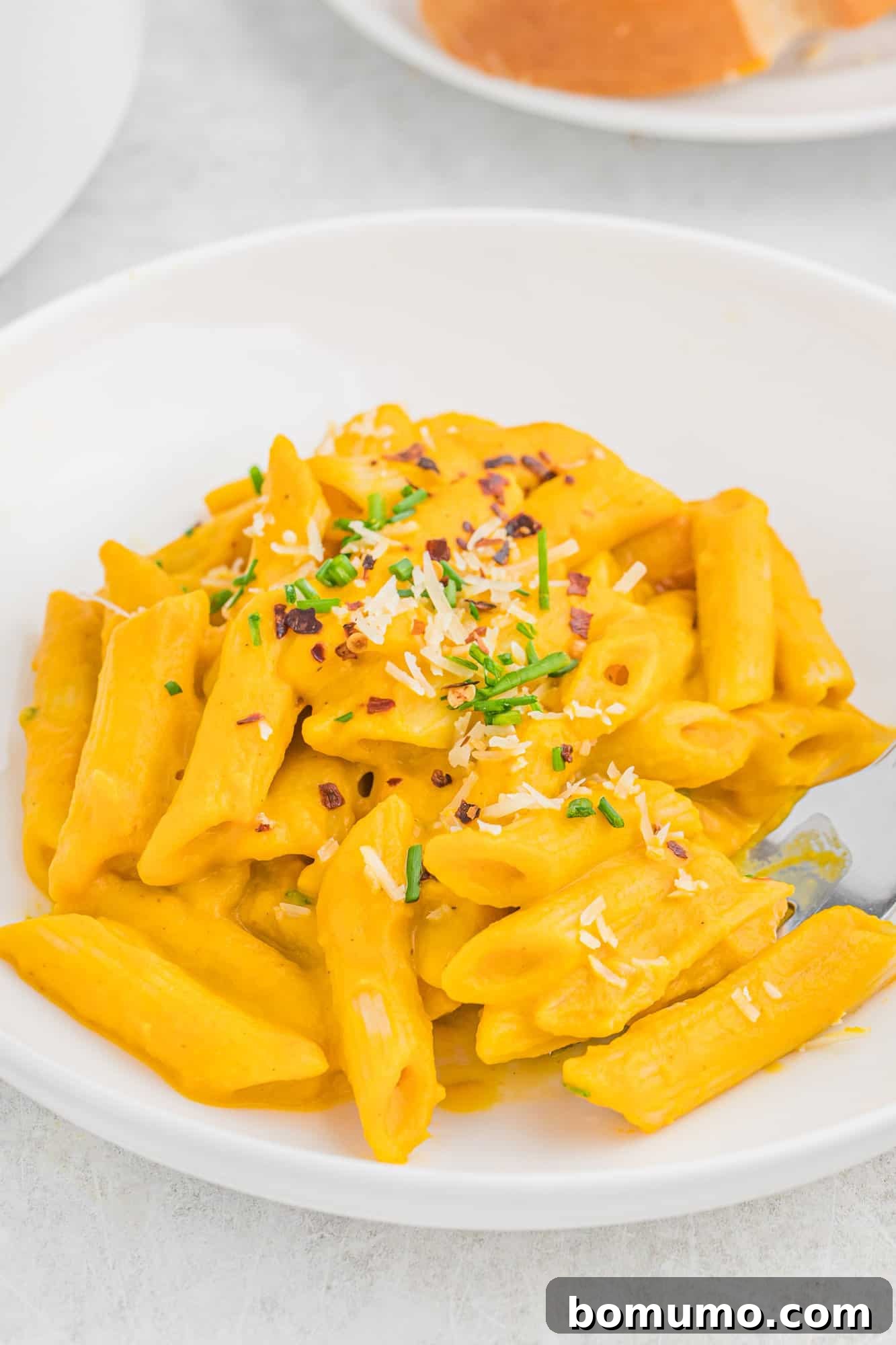 Carrot Sauce Symphony 2 Pasta with carrot pasta sauce in a white bowl.