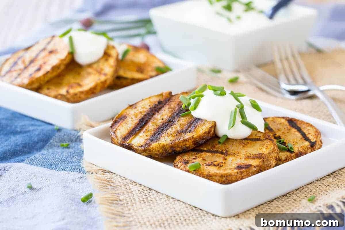 Front view of grilled potatoes on plates with sour cream and chive garnish.