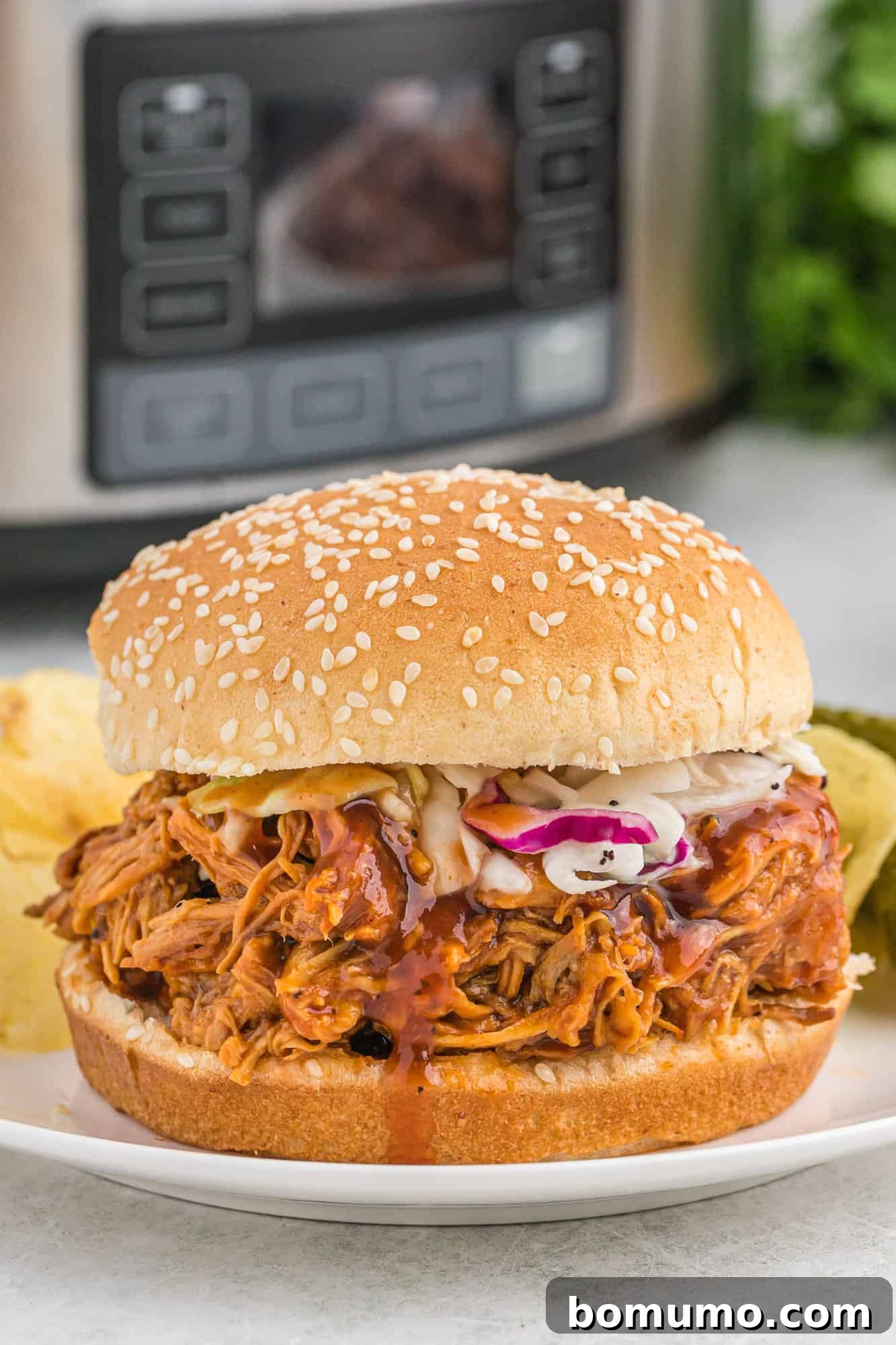Crockpot BBQ chicken on a bun with coleslaw.
