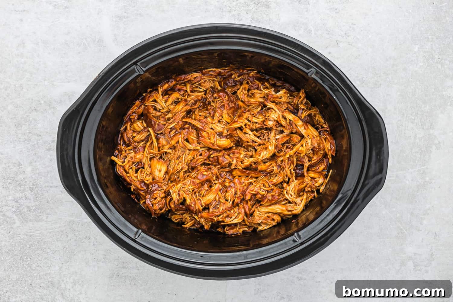 Shredded bbq chicken in a slow cooker.