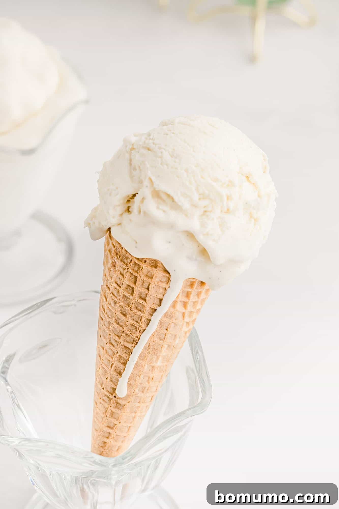 Velvet Vanilla Bliss 2 A scoop of rich, homemade vanilla ice cream in a crisp cone, with melted ice cream gently dripping down the side, showcasing its creamy texture.