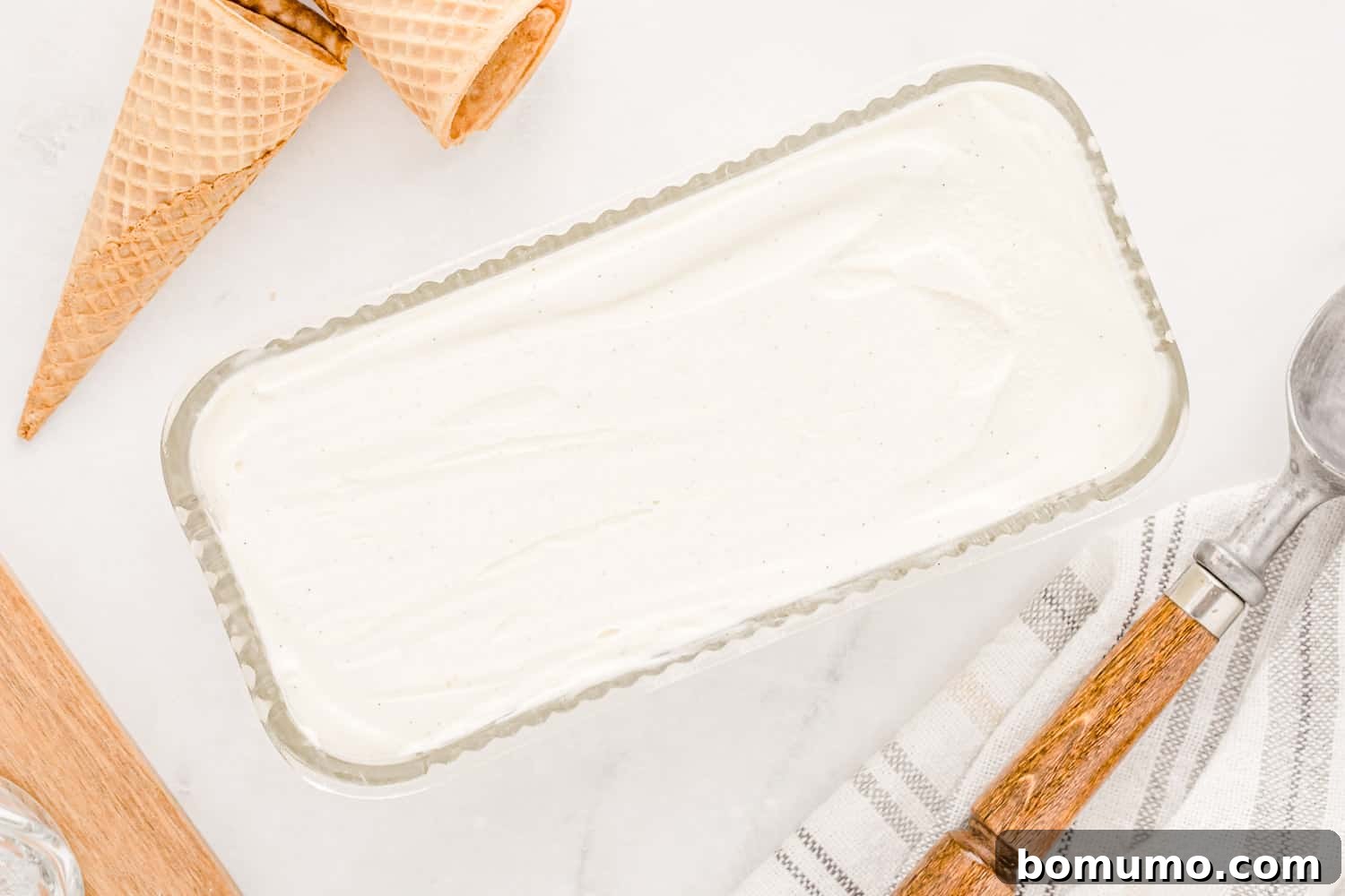 Velvet Vanilla Bliss 5 The smooth, light vanilla ice cream mixture spread evenly into a grey metal loaf pan, ready for freezing.
