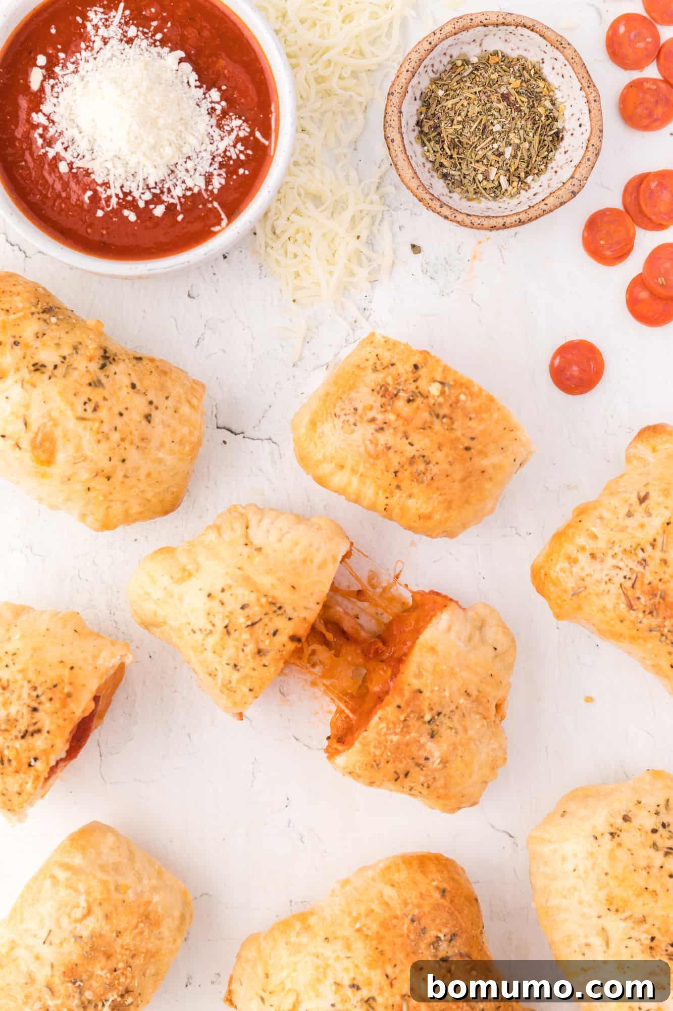 Overhead view of homemade hot pockets, one being pulled apart to show filling. A perfect quick meal or snack.