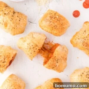 Overhead view of homemade hot pockets, one being pulled apart to show filling, ready to eat.