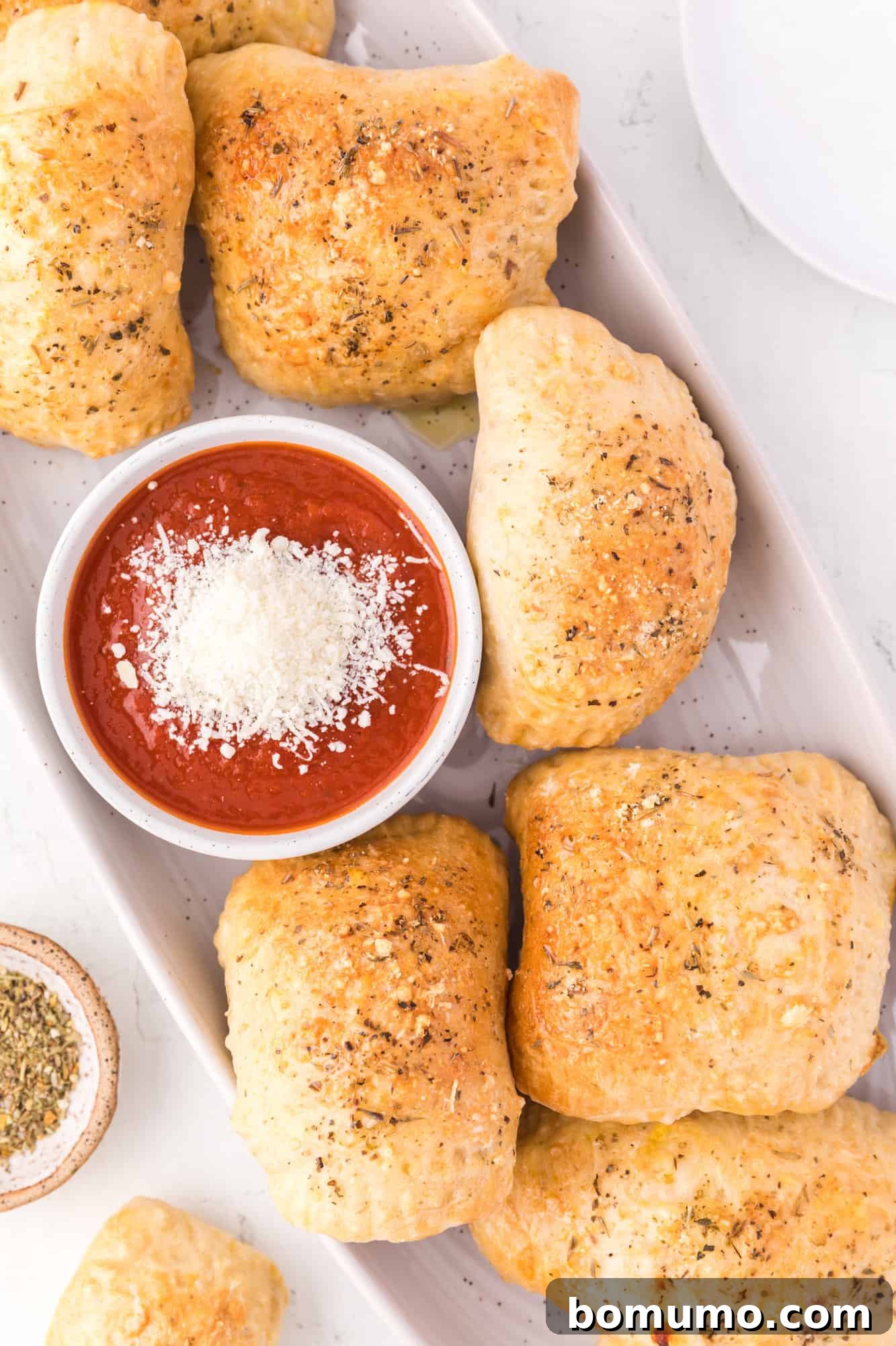 Hot pockets on a long narrow platter with a small bowl of pizza sauce for dipping in the middle. Perfect for sharing.