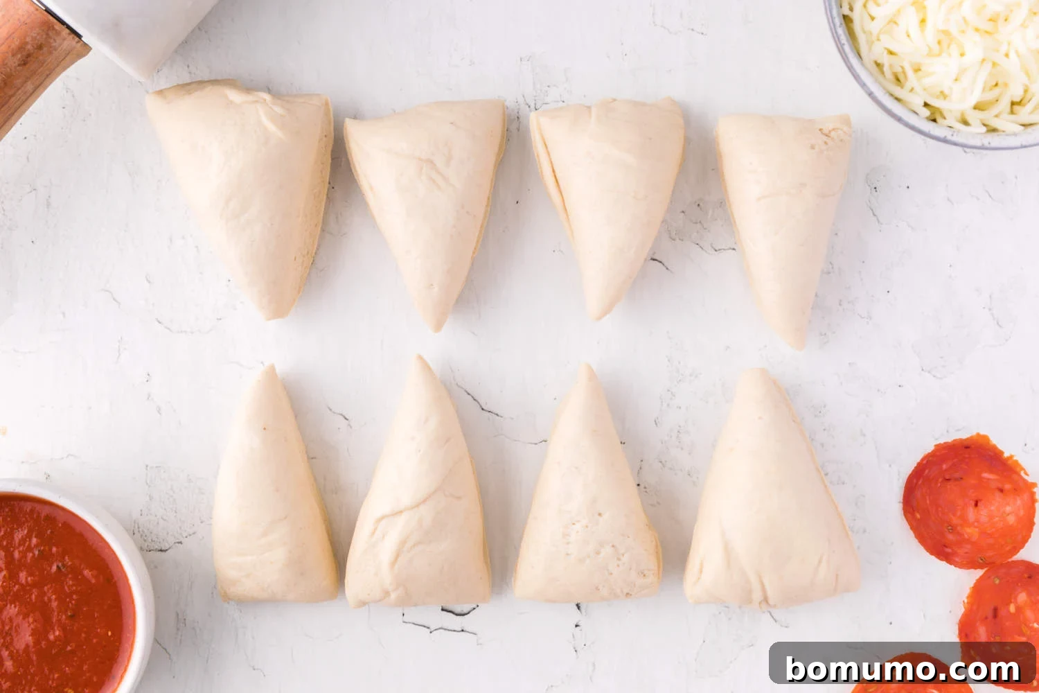 Dough divided into 8 equal portions, ready for rolling and filling.
