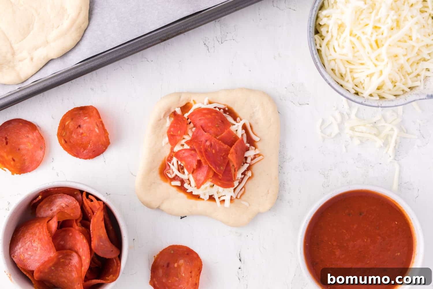 Pepperoni added on top of cheese and sauce, creating a delicious layer for the hot pocket.