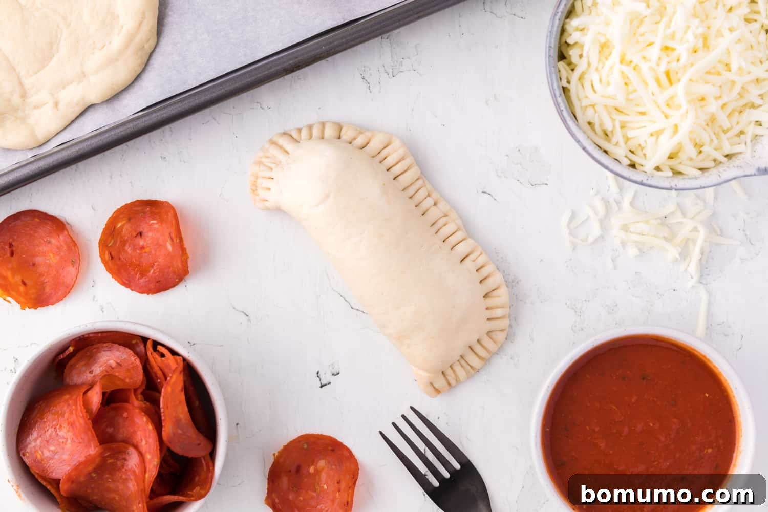 Unbaked hot pocket, showing the securely crimped edges of the crust, ready for baking.