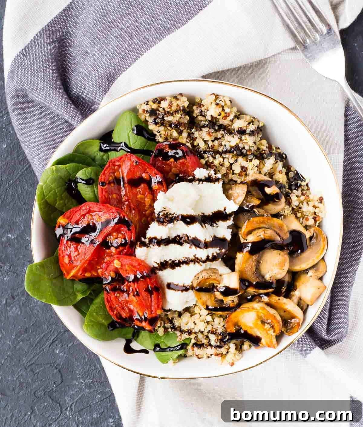 A pristine, shallow white bowl filled with a fresh Quinoa Bowl, ready to be enjoyed.
