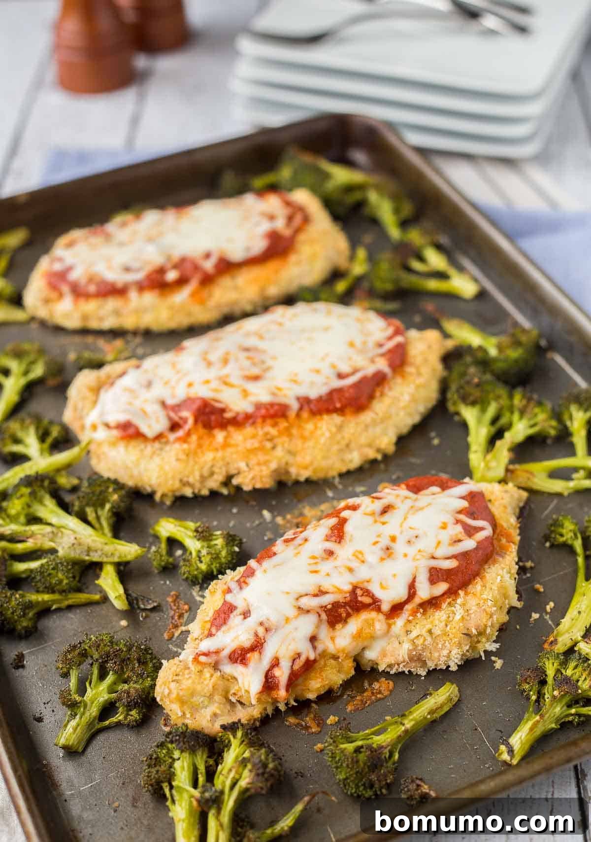Crispy breaded chicken breasts and vibrant roasted broccoli perfectly arranged on a single sheet pan, ready for a healthy and easy weeknight dinner.