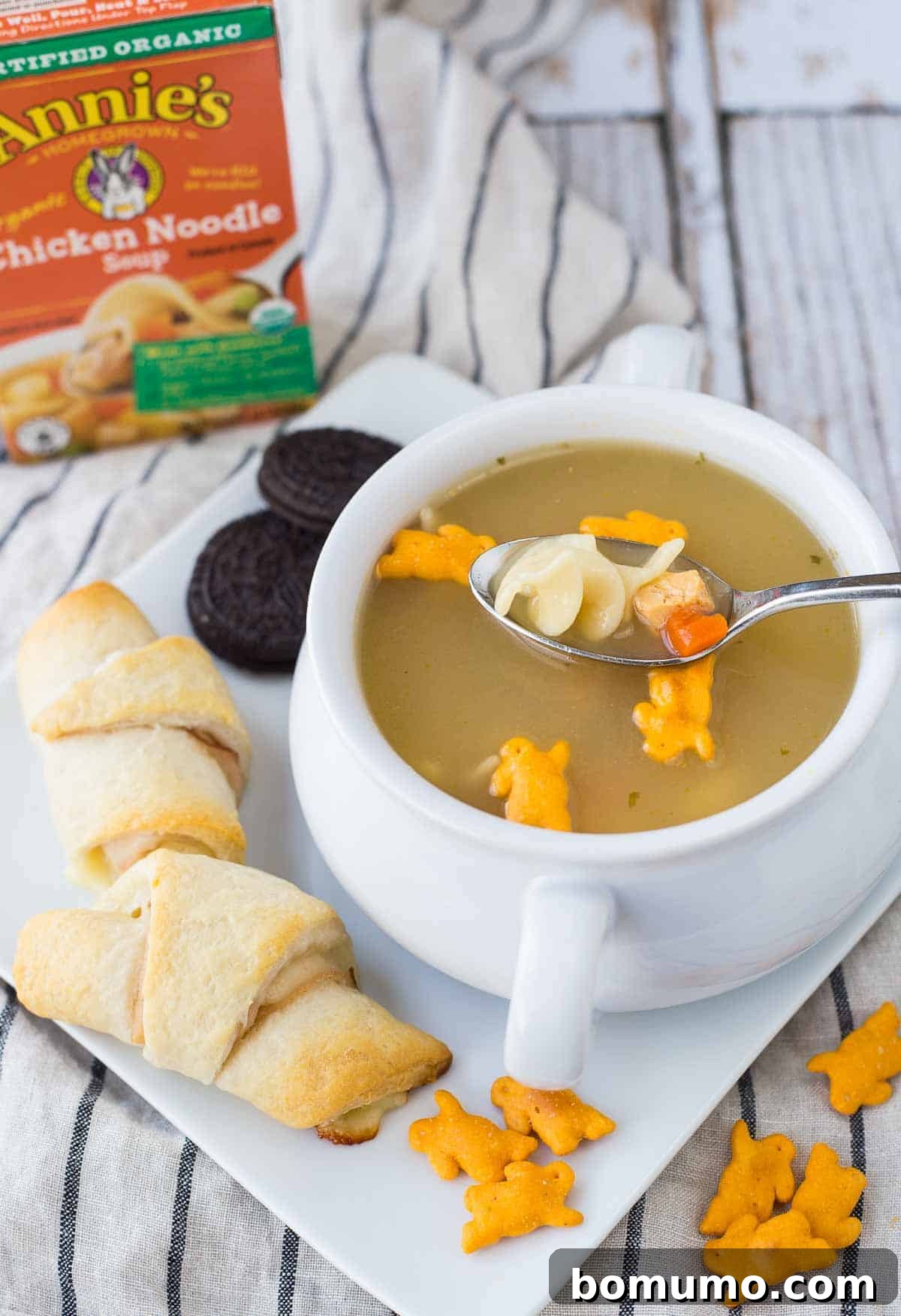Soup garnished with bunny crackers, with spoon inserted.