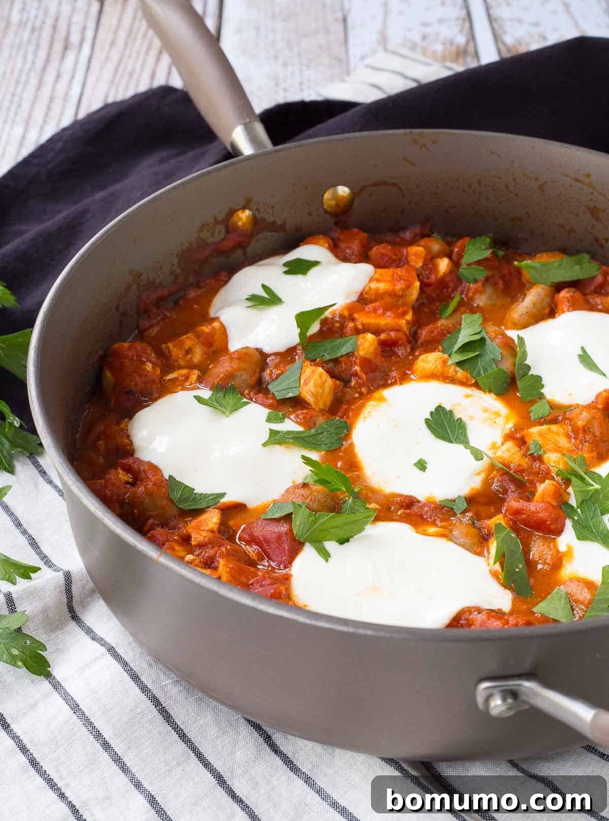 Partial image of large skillet containing gnocchi with chicken and tomato sauce.