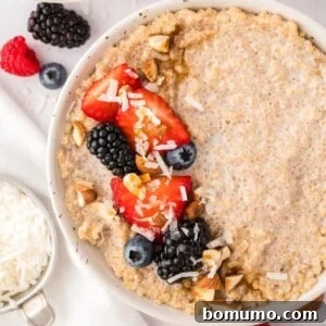 A beautifully presented bowl of breakfast quinoa, generously topped with an assortment of fresh berries and crunchy nuts.