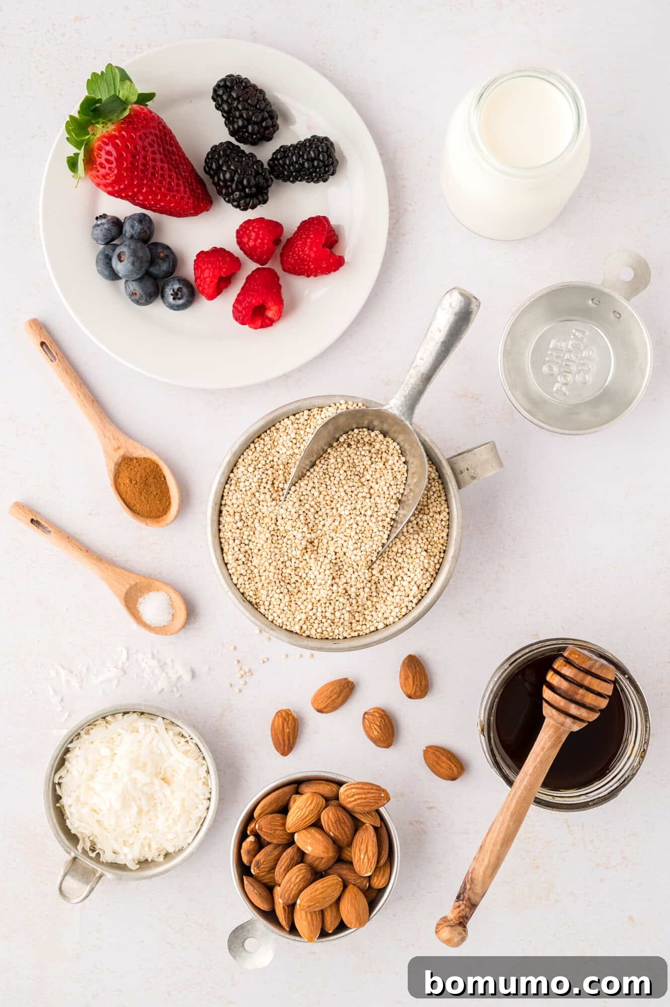 An overhead view showcasing all the fresh and dry ingredients required for the breakfast quinoa recipe, meticulously arranged, including a variety of colorful toppings.