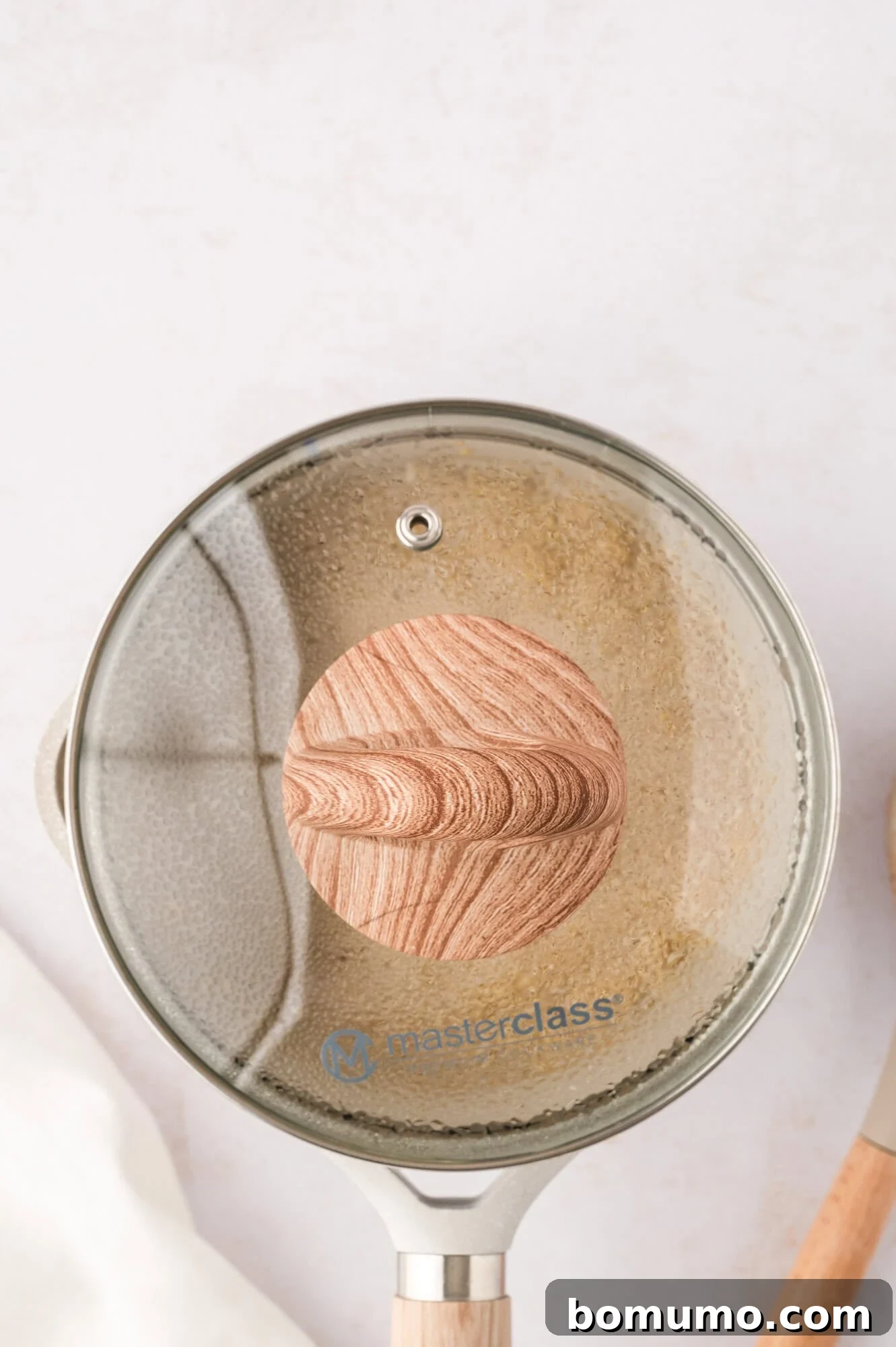 A saucepan containing cooked quinoa, securely covered with a lid to allow for resting and optimal liquid absorption.