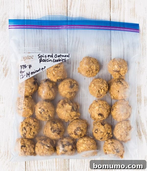 Scooped cookie dough balls arranged on a tray lined with parchment paper, ready for freezing.