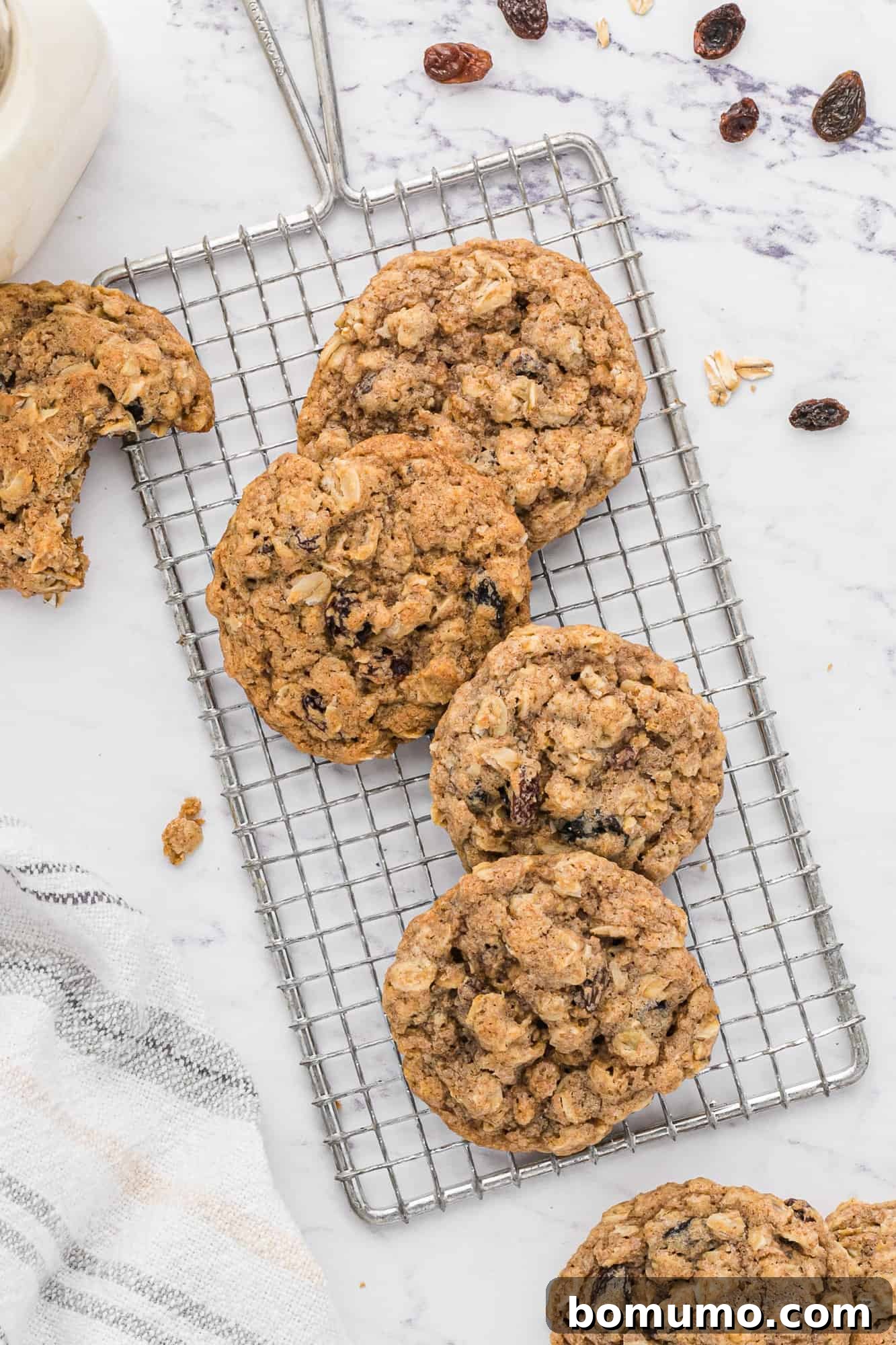 Freshly baked oatmeal raisin cookies cooling on a wire rack.