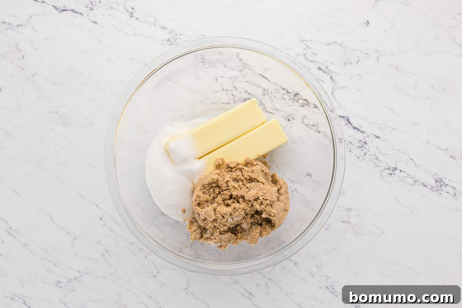 Softened butter and a mixture of brown and granulated sugars in a large mixing bowl.