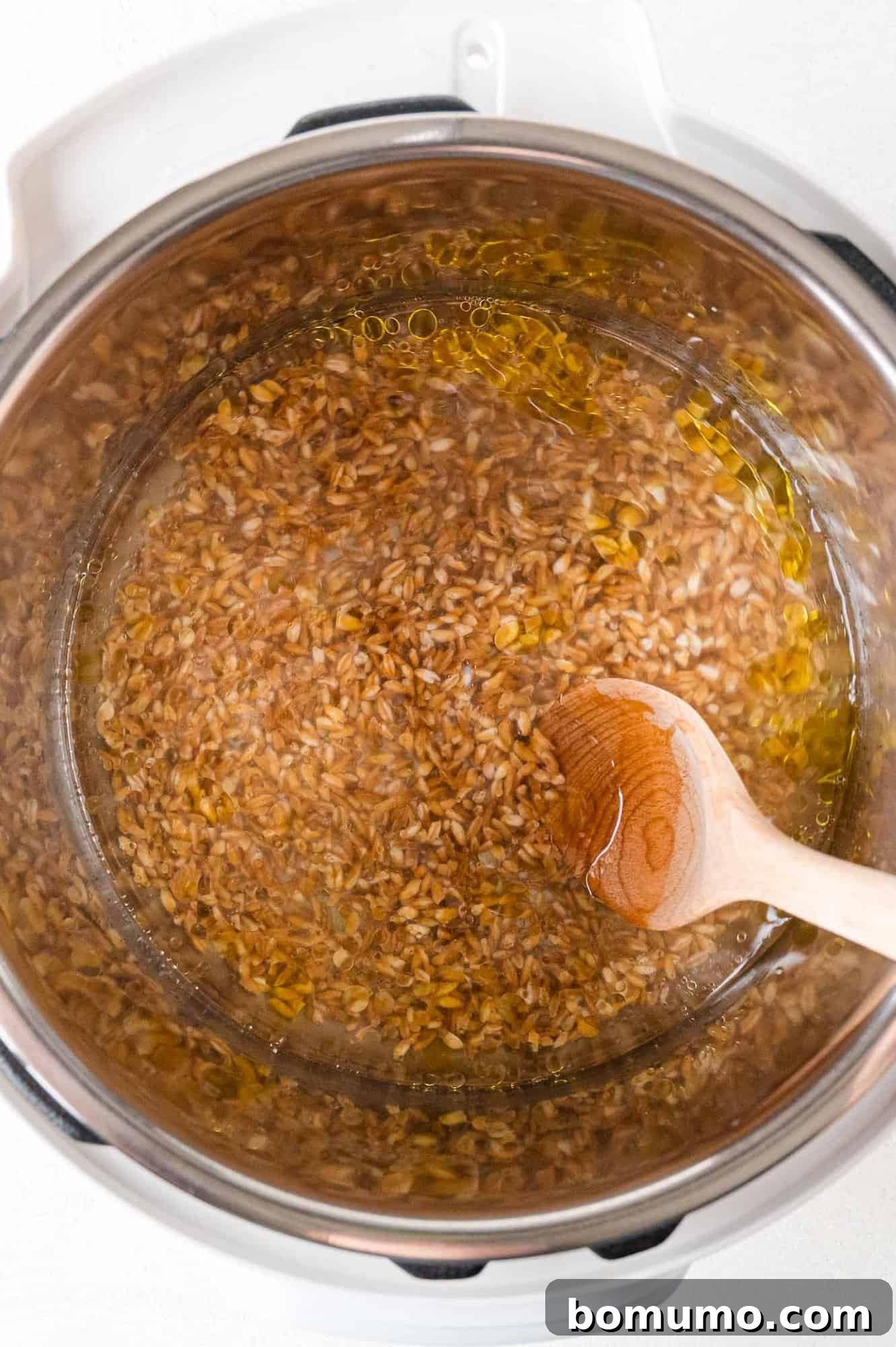 Effortless Instant Pot Farro 8 Farro ingredients being stirred together in an Instant Pot before cooking.