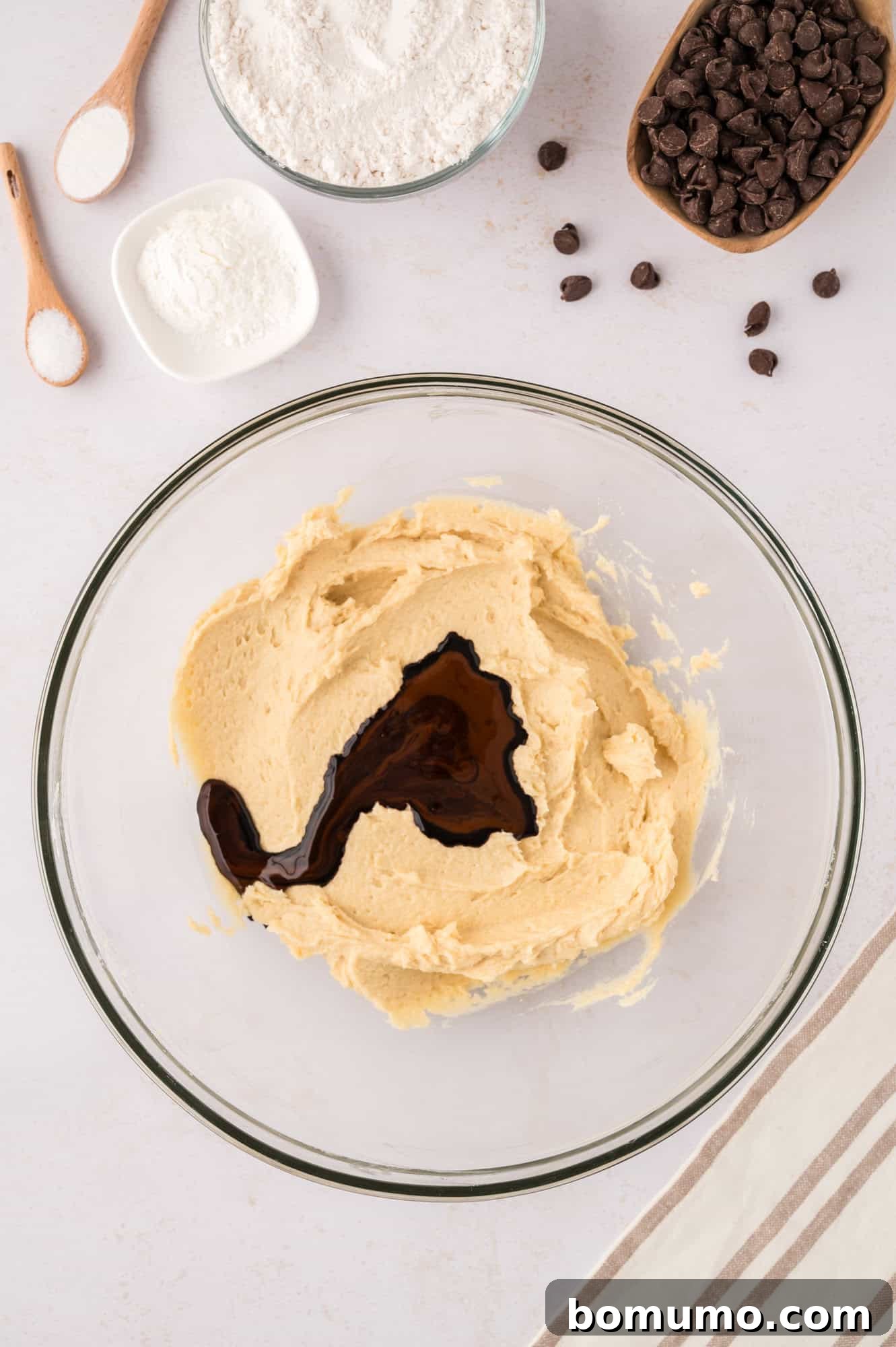 The dissolved espresso mixture being poured into the cookie batter, adding the signature coffee flavor.