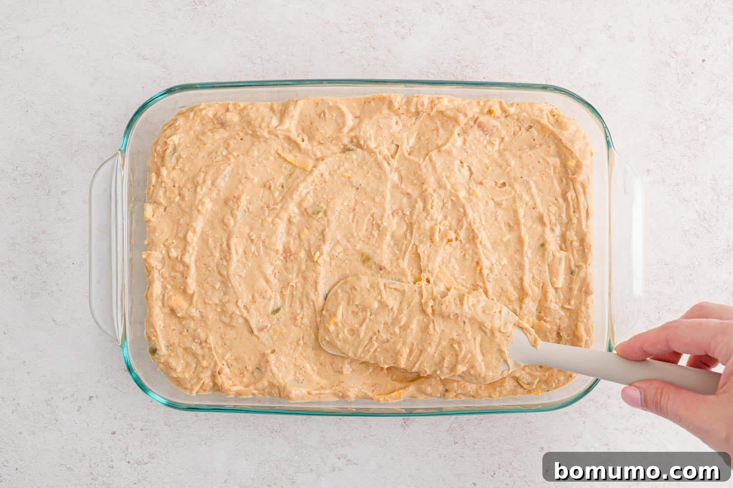 Smooth Bean Party Pleaser 9 Bean dip mixture spread evenly into a baking dish, ready for the final touches.