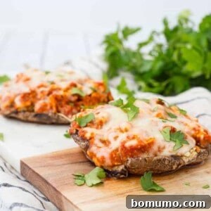 Two servings of stuffed mushrooms on cutting board, garnished with chopped parsley.
