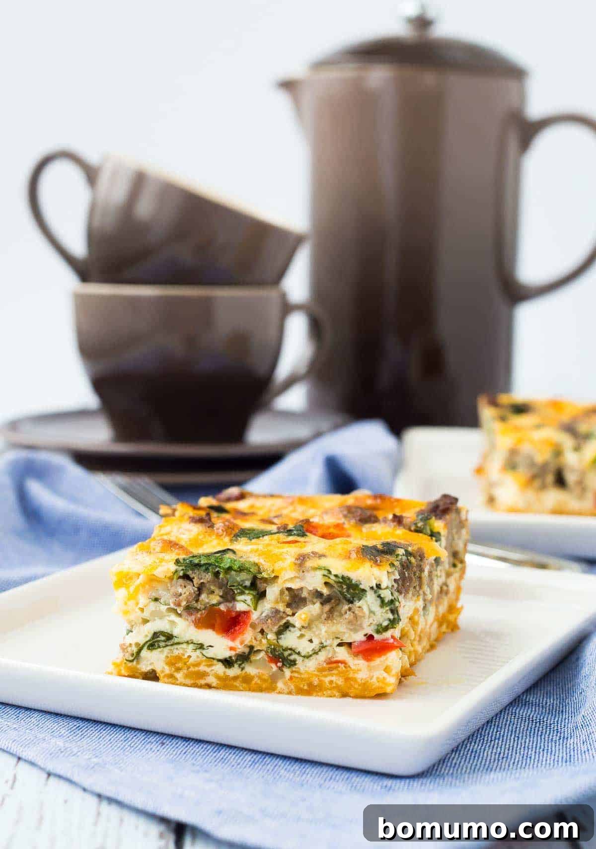 A perfectly portioned serving of a golden-brown egg white casserole with a sweet potato crust, garnished with fresh herbs, resting on a square white plate. A steaming cup of coffee and a warm, inviting background complete the scene, highlighting a fulfilling breakfast experience.