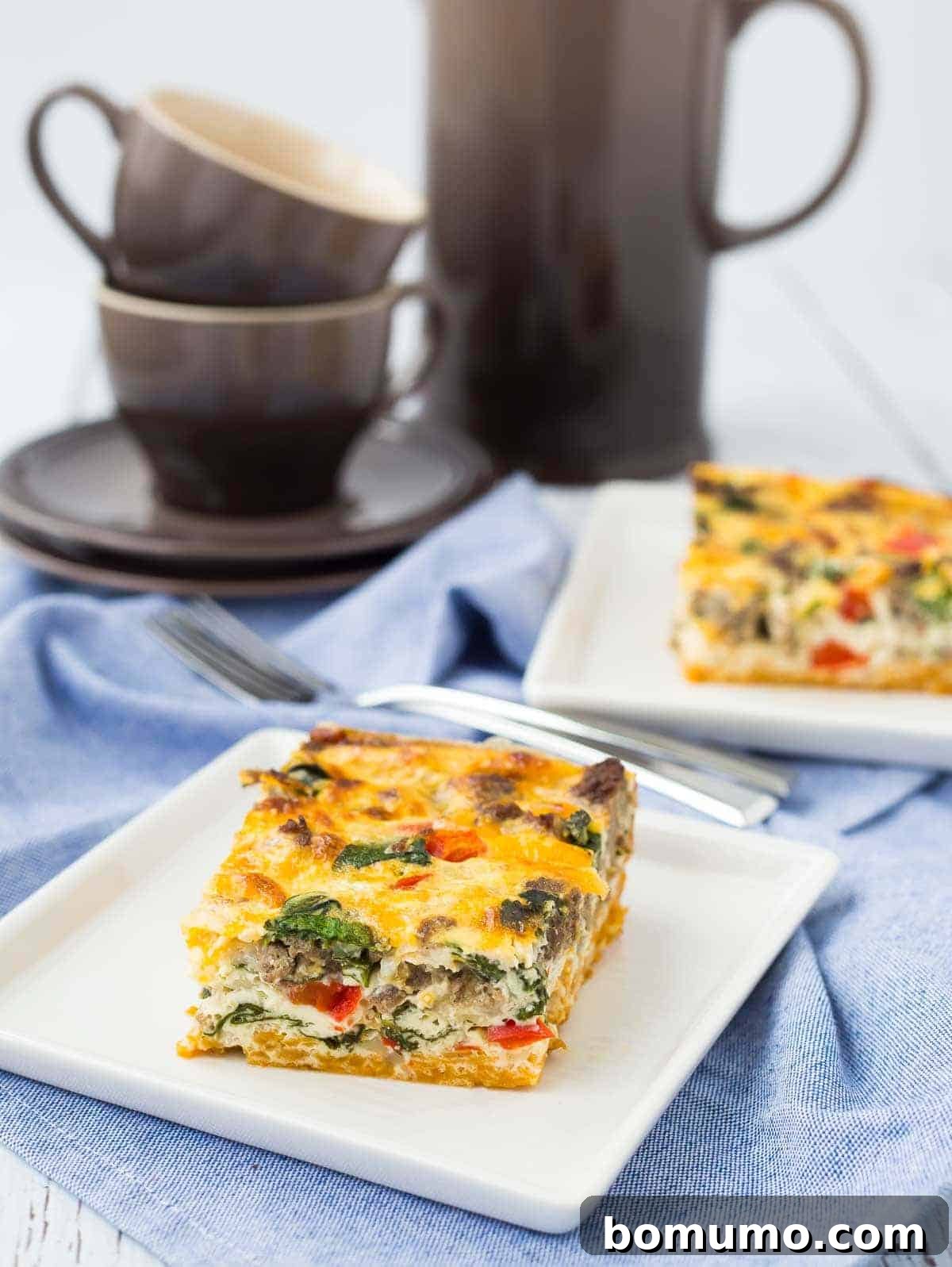 Several servings of a vibrant egg white casserole, showcasing the golden sweet potato crust and colorful vegetable-and-sausage filling, arranged on a rustic wooden table. In the background, stylish coffee mugs and a carafe hint at a complete and comforting breakfast spread, ready to be enjoyed.