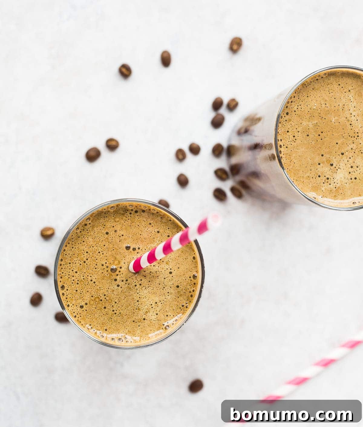 An inviting overhead shot of a mocha protein shake, artfully arranged with scattered coffee beans on a rustic wooden surface, emphasizing its rich, coffee-infused essence and inviting texture.