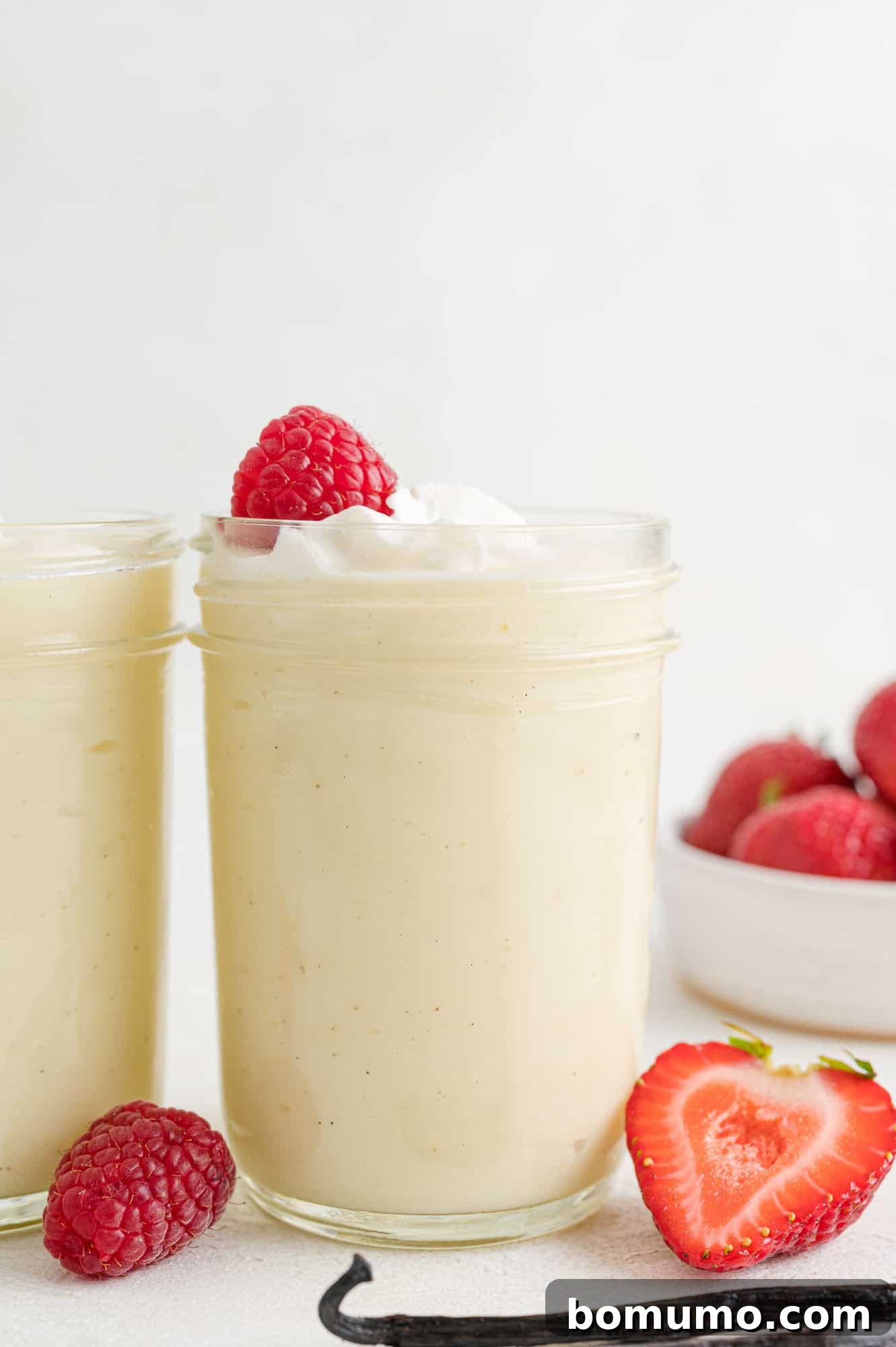 Dreamy Vanilla Pudding from Scratch 2 Vanilla pudding in a jar with whipped cream and a strawberry.