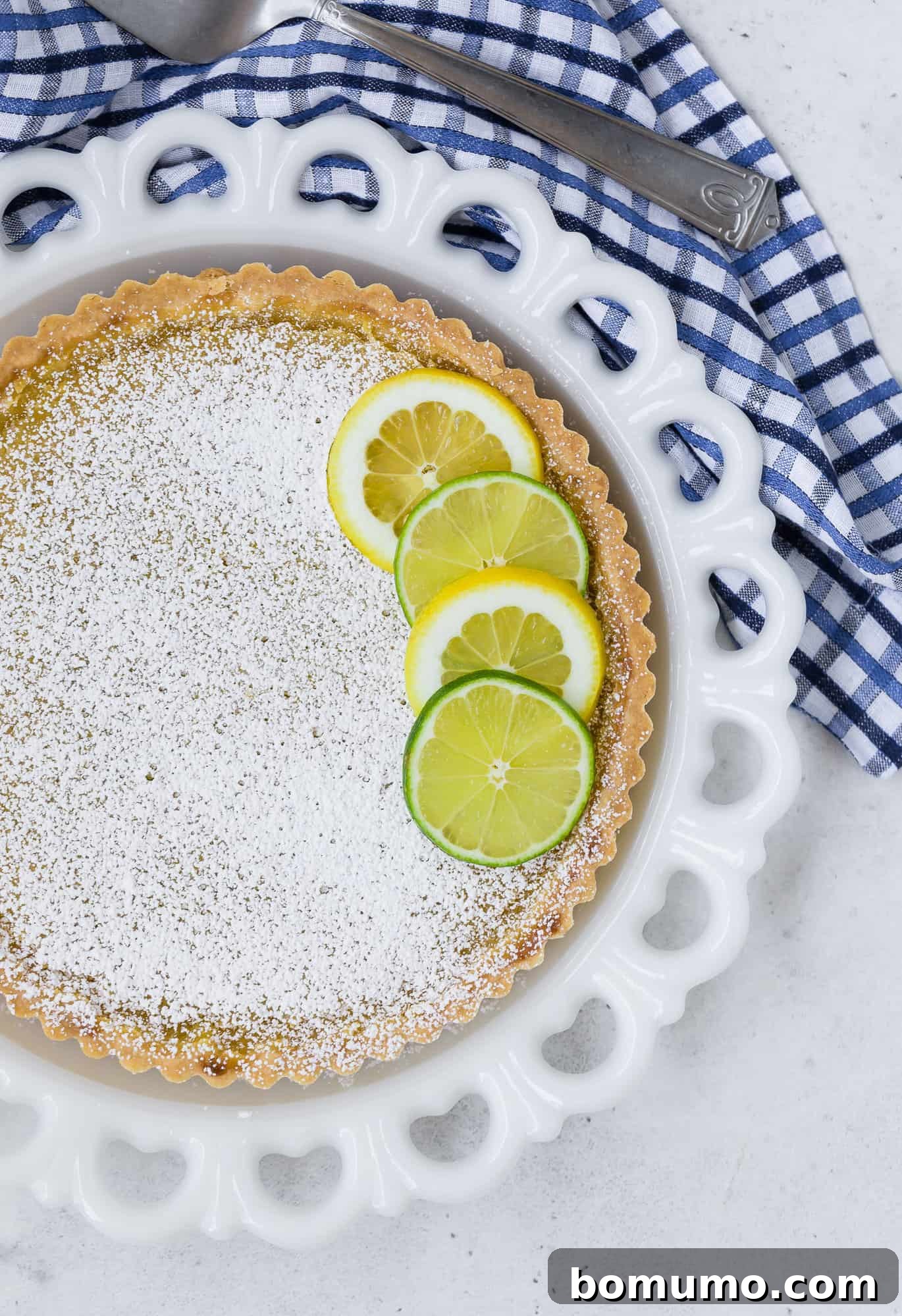 Overhead view of a beautifully baked lemon lime tart, showcasing its golden shortbread crust and vibrant citrus filling.