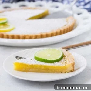 Slice of lemon lime tart, featuring the vibrant filling and golden crust.