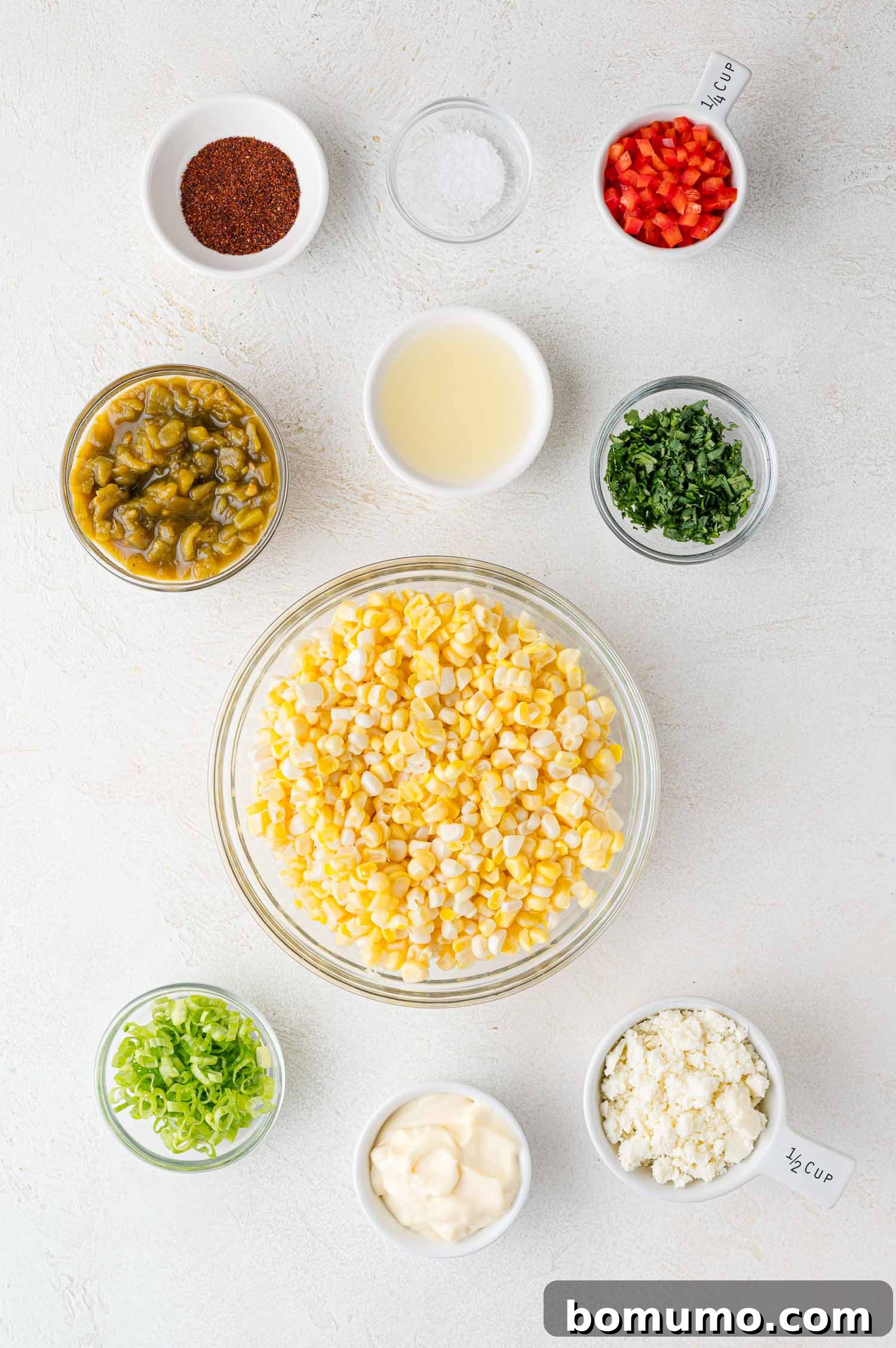 A vibrant bowl of Mexican street corn dip, brimming with colorful ingredients like yellow corn, red bell peppers, and green cilantro, beckoning for a chip.