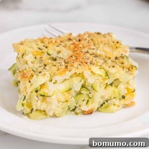 A slice of golden-brown zucchini casserole with rice, cheese, and a crispy panko topping.