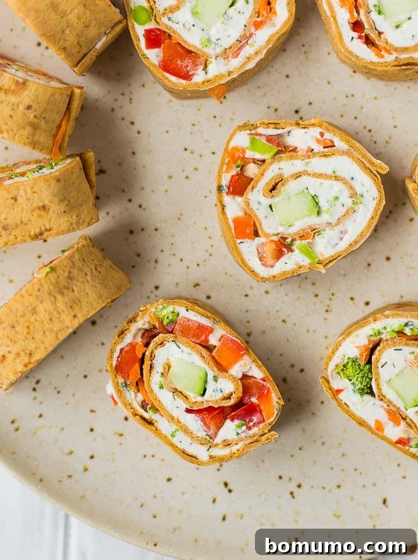 Creamy Veggie Pinwheels 2 Freshly sliced vegetable cream cheese rolls ups showcasing their colorful and creamy filling.