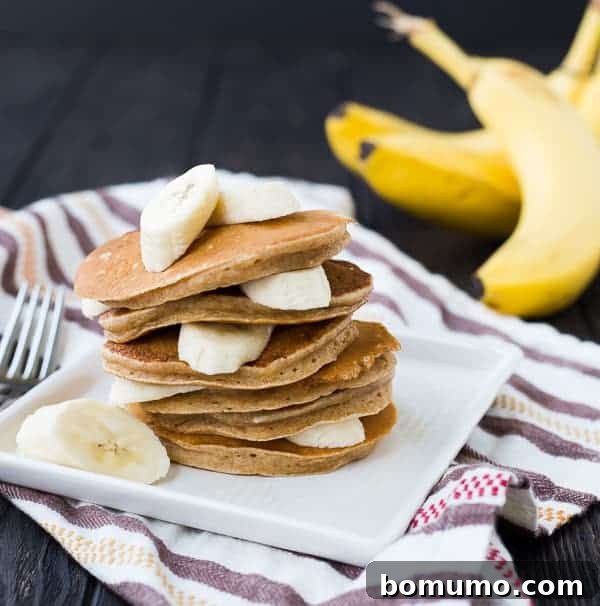 Close-up of healthy banana pancakes layered with fresh banana slices, showcasing their fluffy texture.