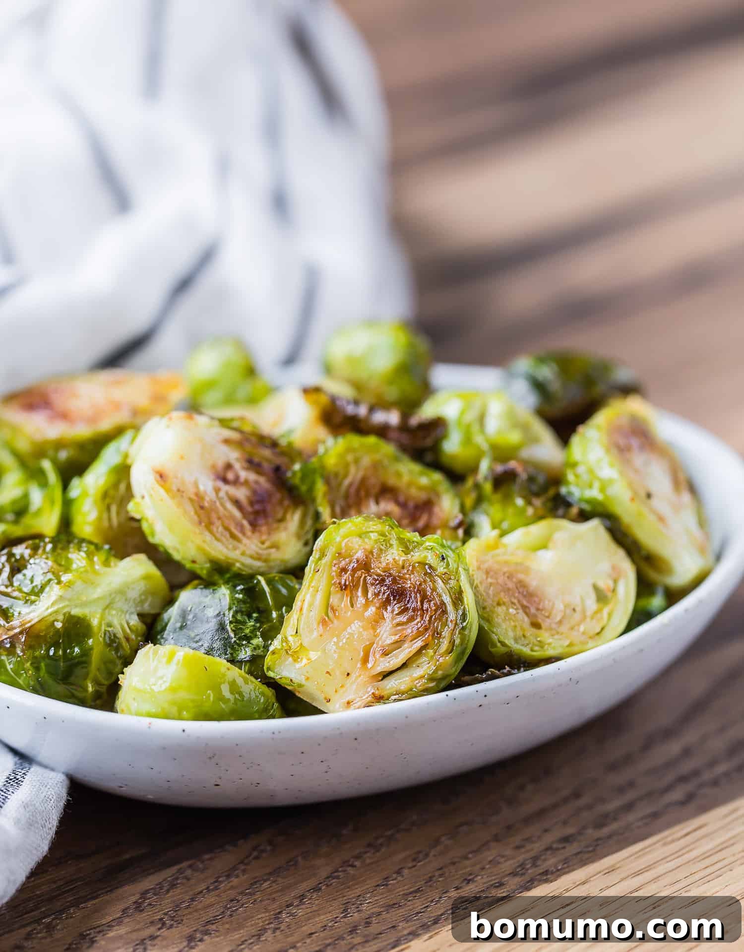 Perfectly roasted maple cayenne Brussels sprouts served in a small elegant bowl, ready to enjoy.