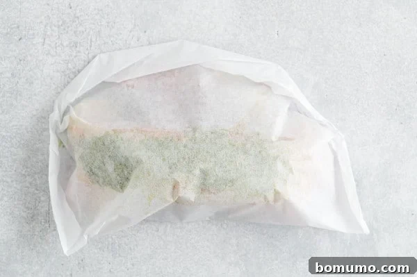 A perfectly folded and sealed parchment paper packet, ready for baking, showcasing the 'en papillote' technique.