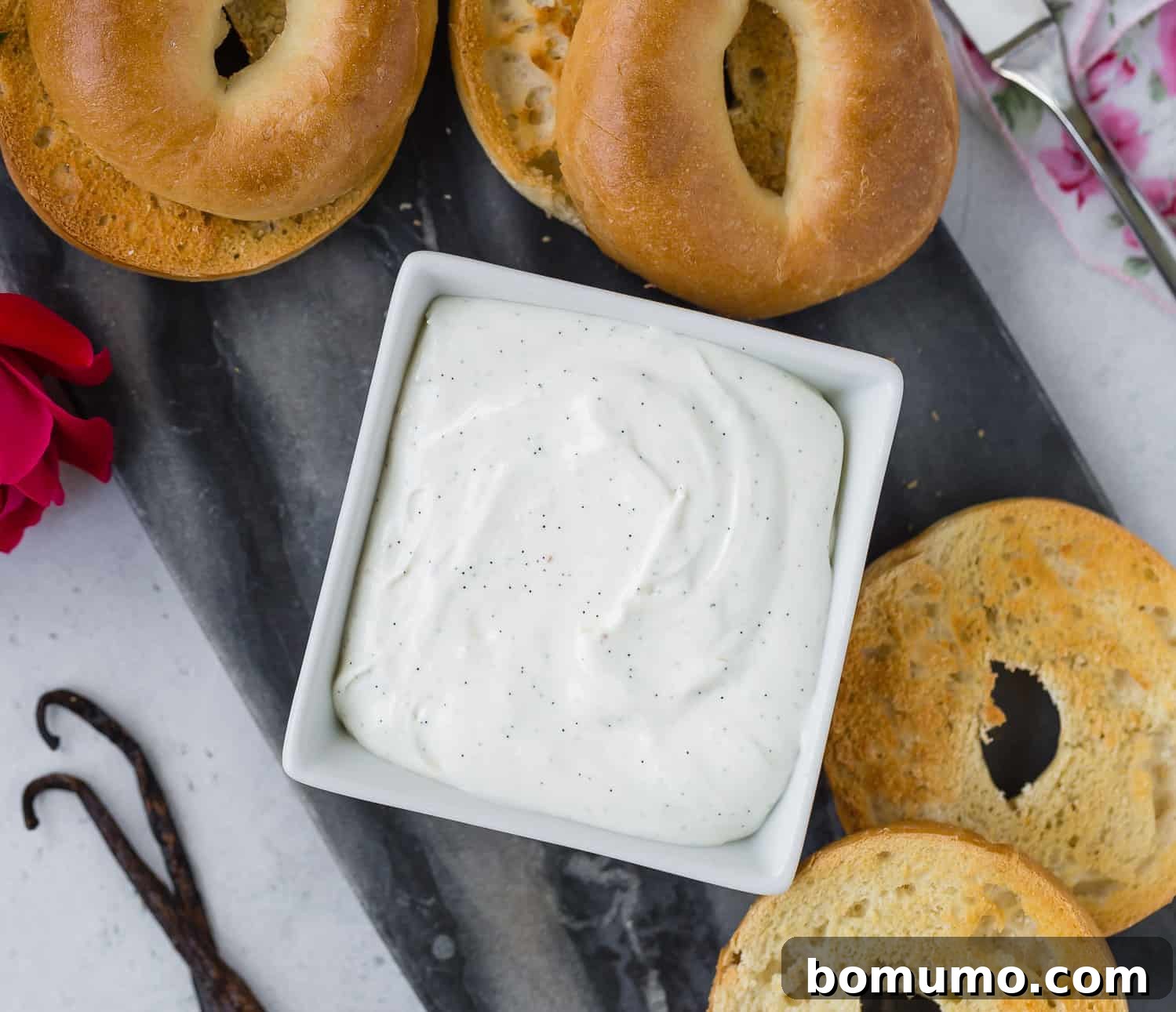 Cream cheese in a dish surrounded by bagels, inviting to be spread and enjoyed.