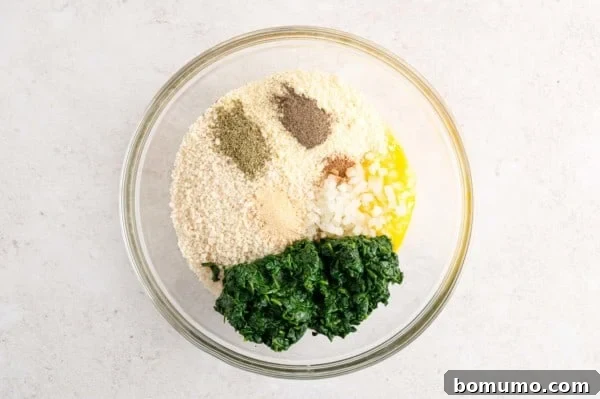 Spinach ball ingredients combined in a glass bowl.