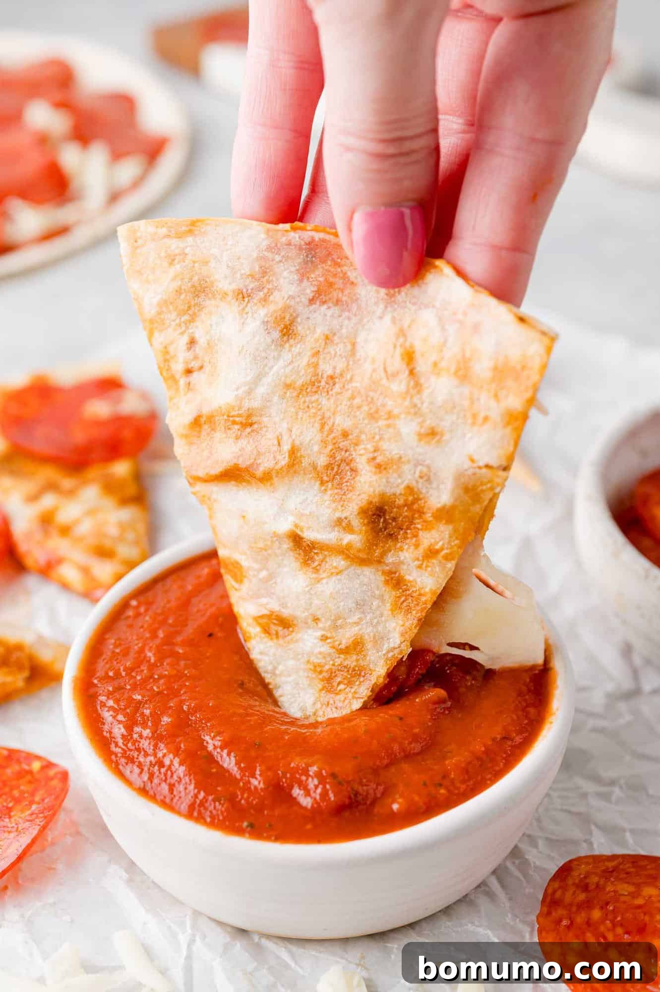 Pizza-Dilla Melt 3 A perfectly cooked pizza quesadilla, golden brown and cheesy, ready to be dipped into a side of warm pizza sauce.