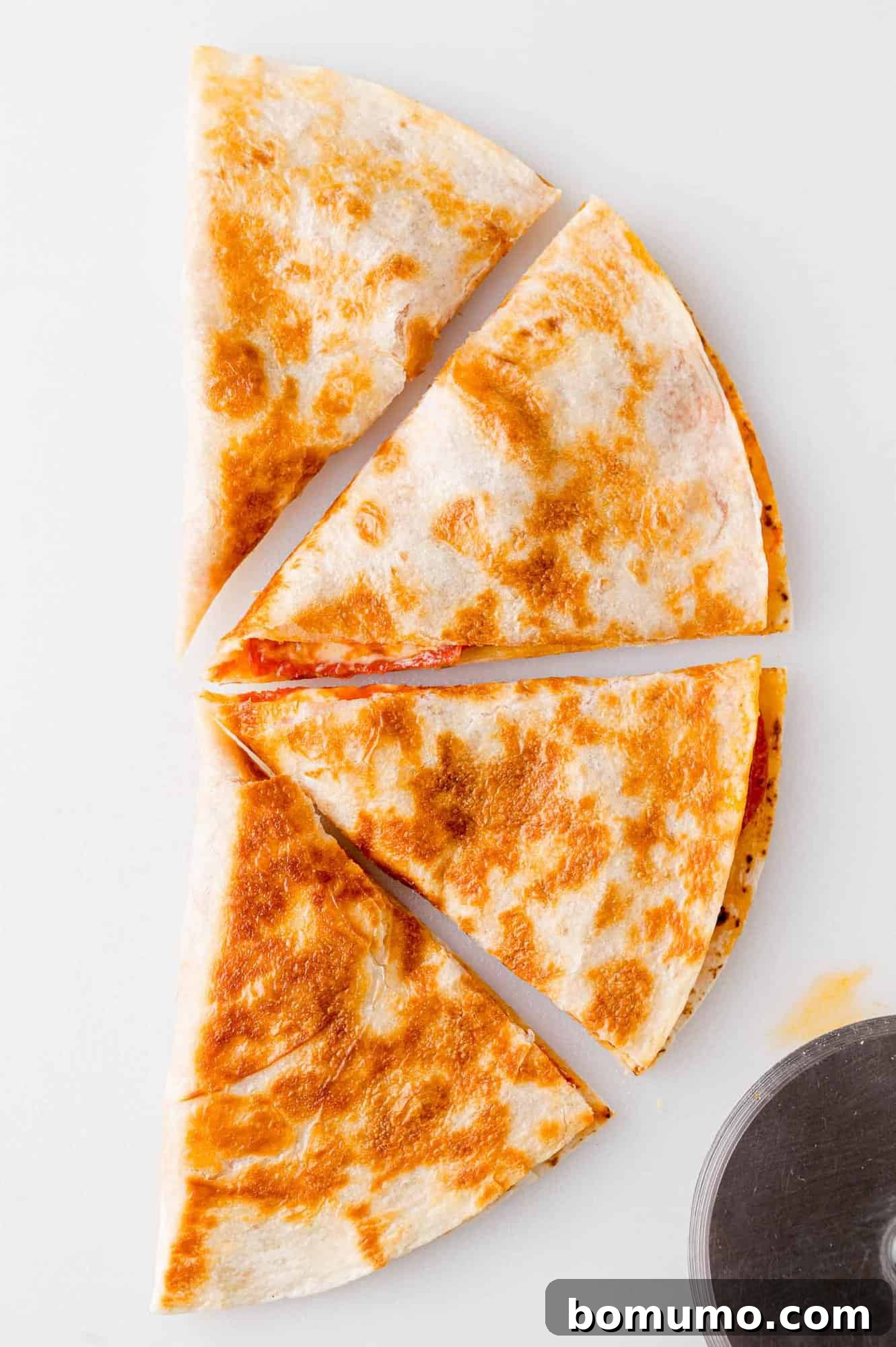 Pizza-Dilla Melt 10 A beautifully cut pizza quesadilla, divided into four tempting wedges, ready to be enjoyed.