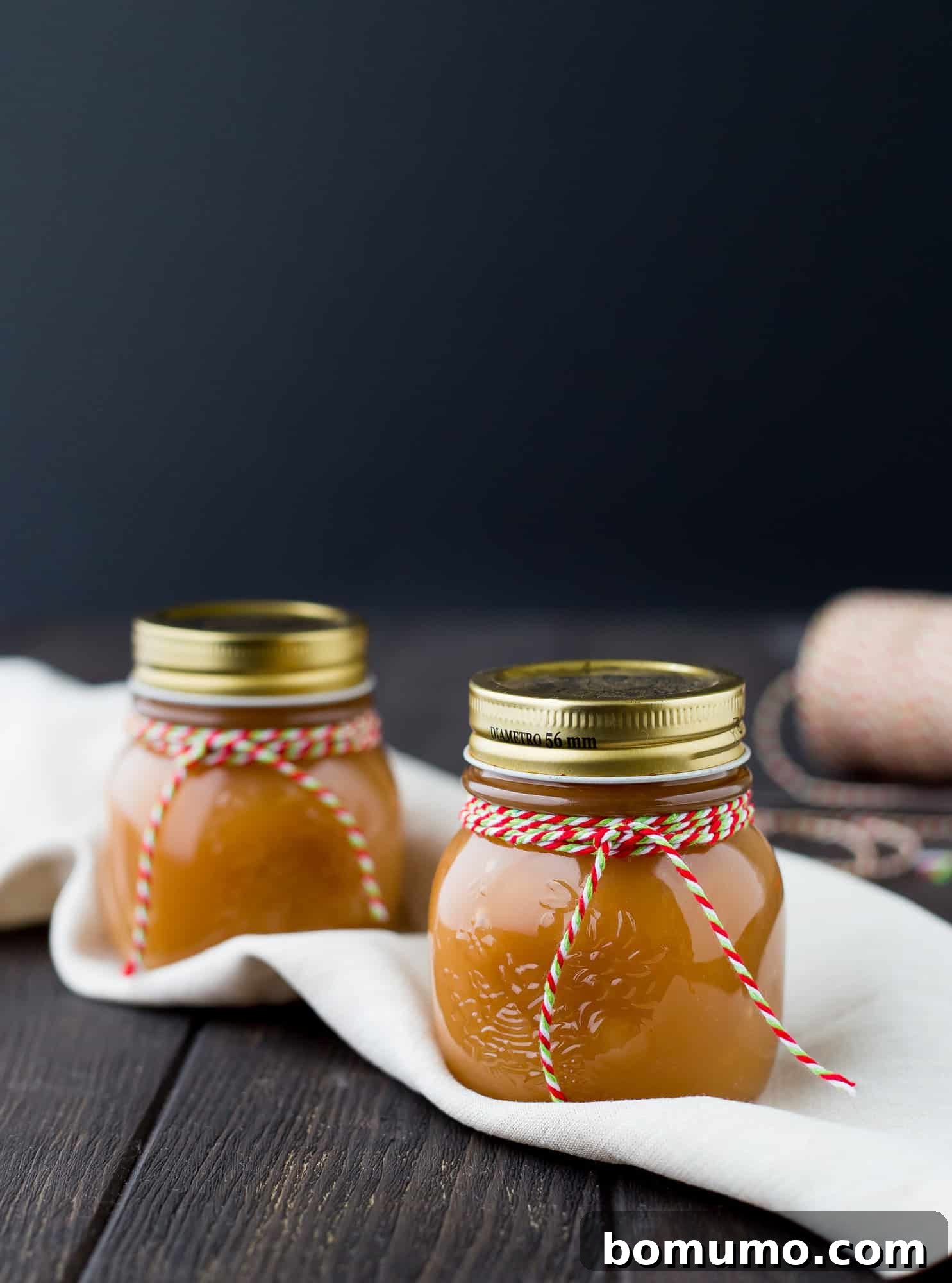 Decadent Bourbon Caramel Drizzle 3 Two small, clear glass jars filled with golden Bourbon Caramel Sauce, ready for gifting or enjoying.
