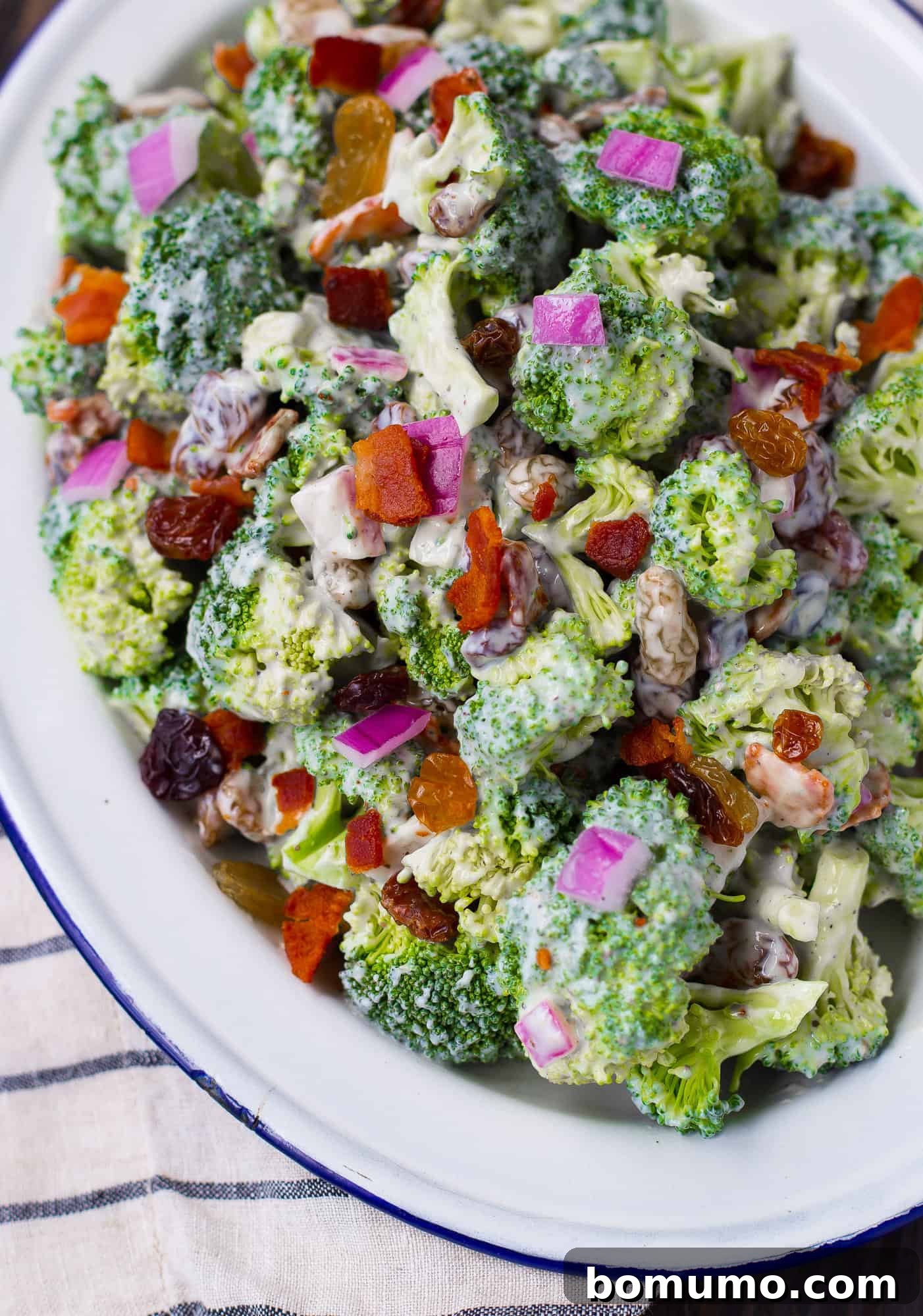 Broccoli salad on a blue and white plate, ready to serve.